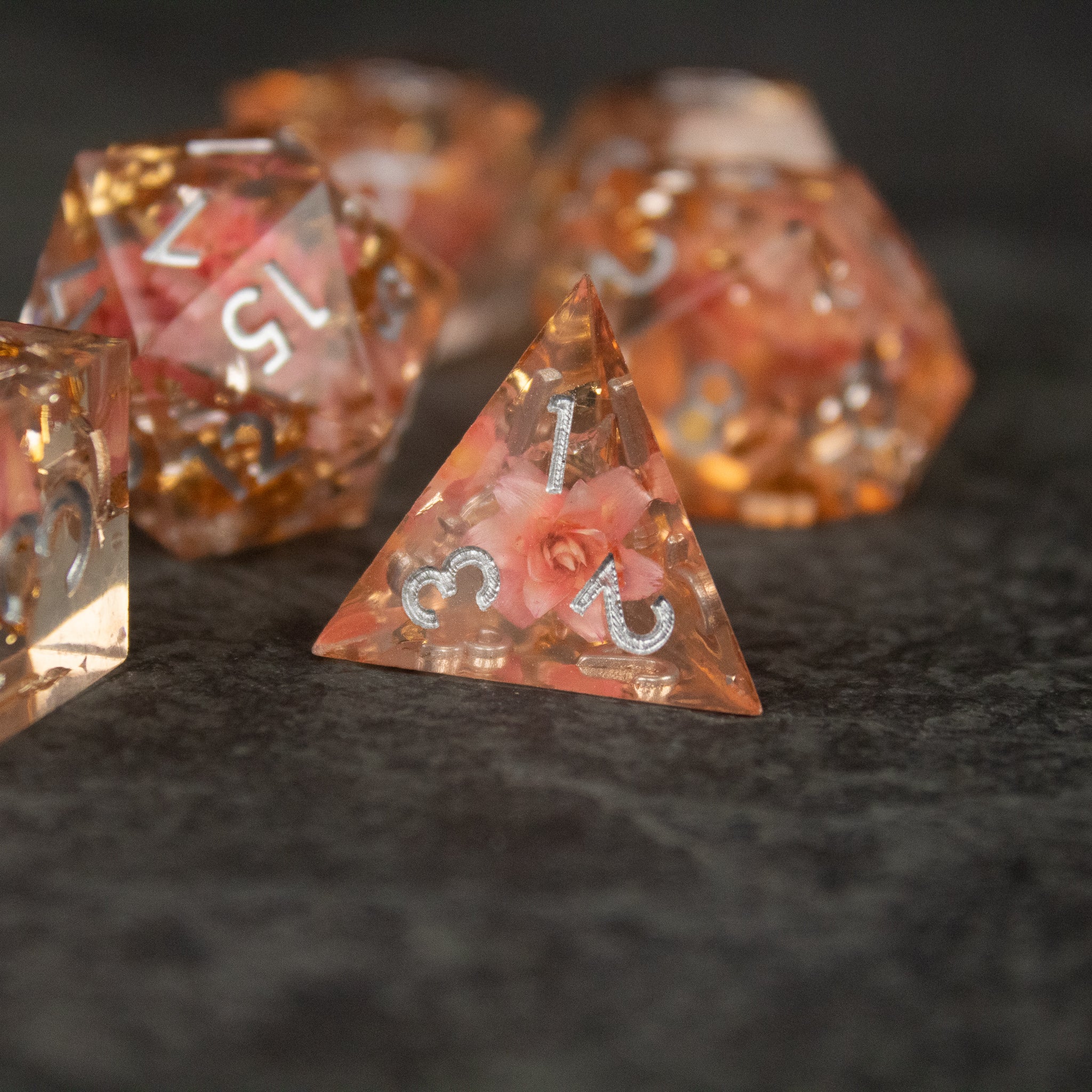 Pink Flower Sharp Edge Dice Set - Set of sharp-edged translucent pink dice containing embedded delicate flower petals, white numbering.
