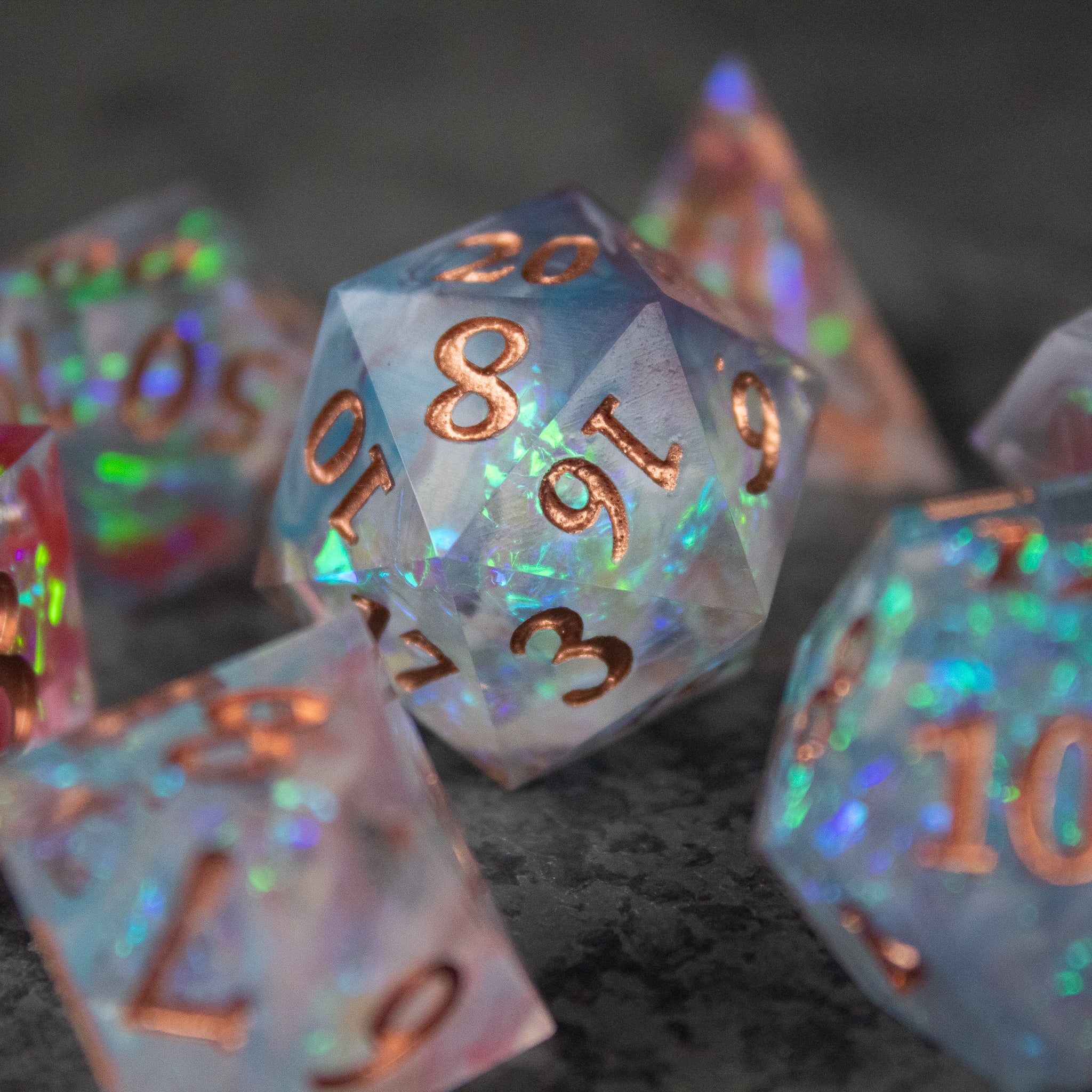 Divination Dice Set - Translucent sharp-edged d20 dice with iridescent blue, purple, and green flecks and copper numbers.