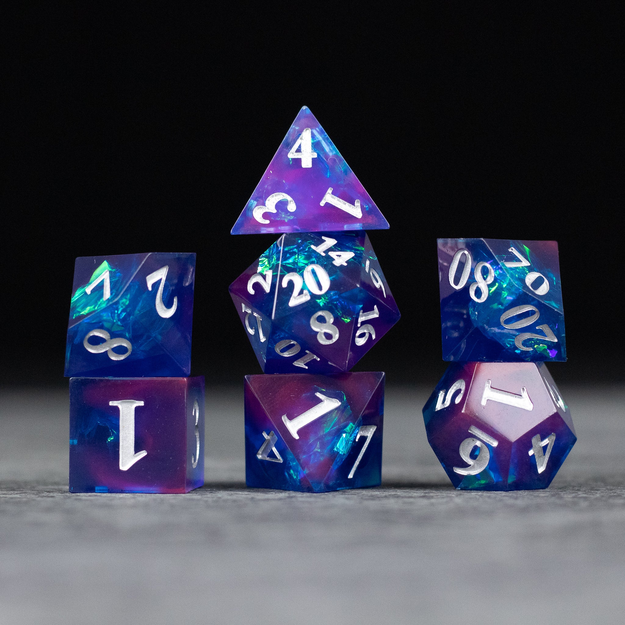 Midnight Blue Dice Set - Set of seven sharp-edged dice in midnight blue and purple tones with white numbering.