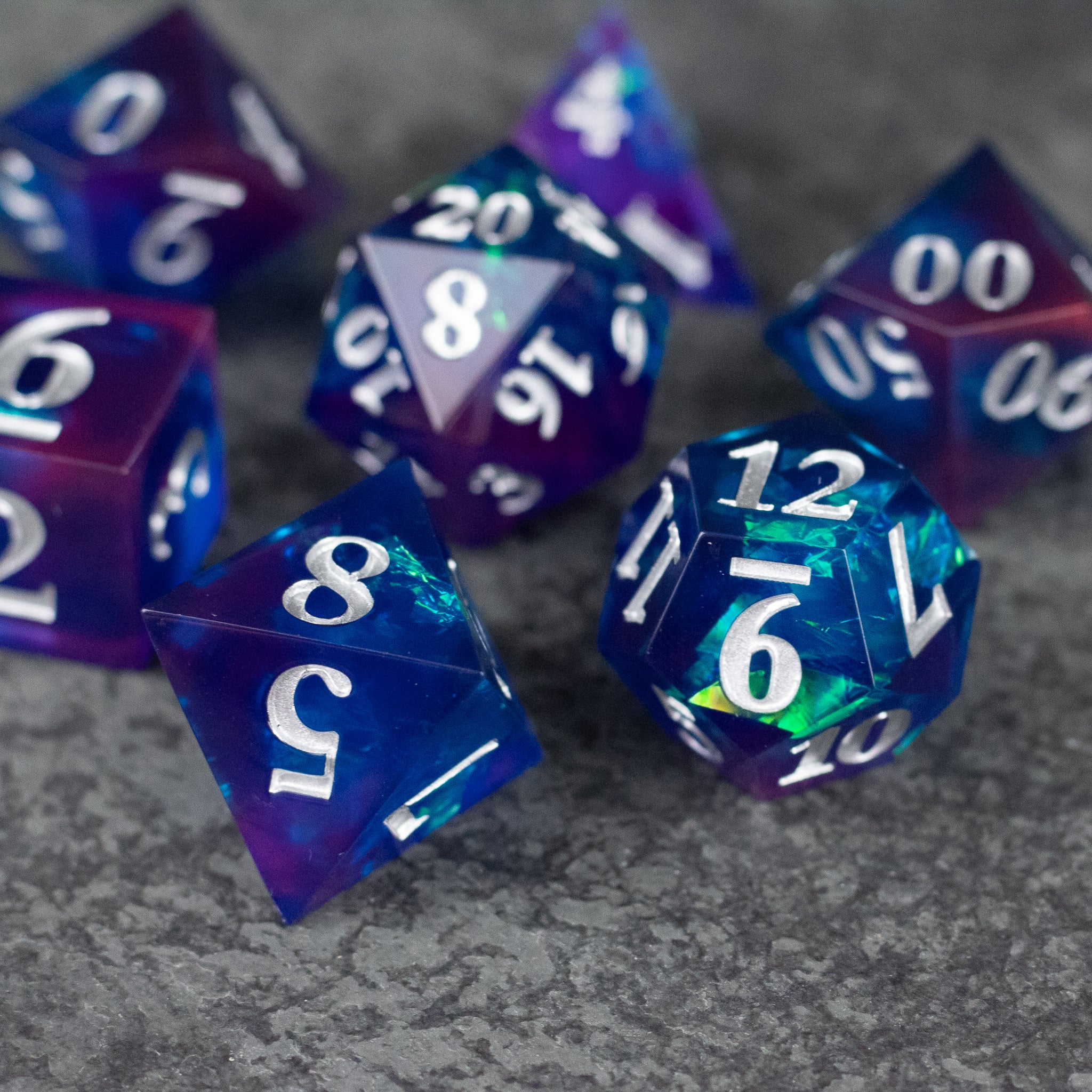 Midnight Blue Dice Set - Set of translucent midnight blue sharp-edged dice with white numbering on a textured gray surface.