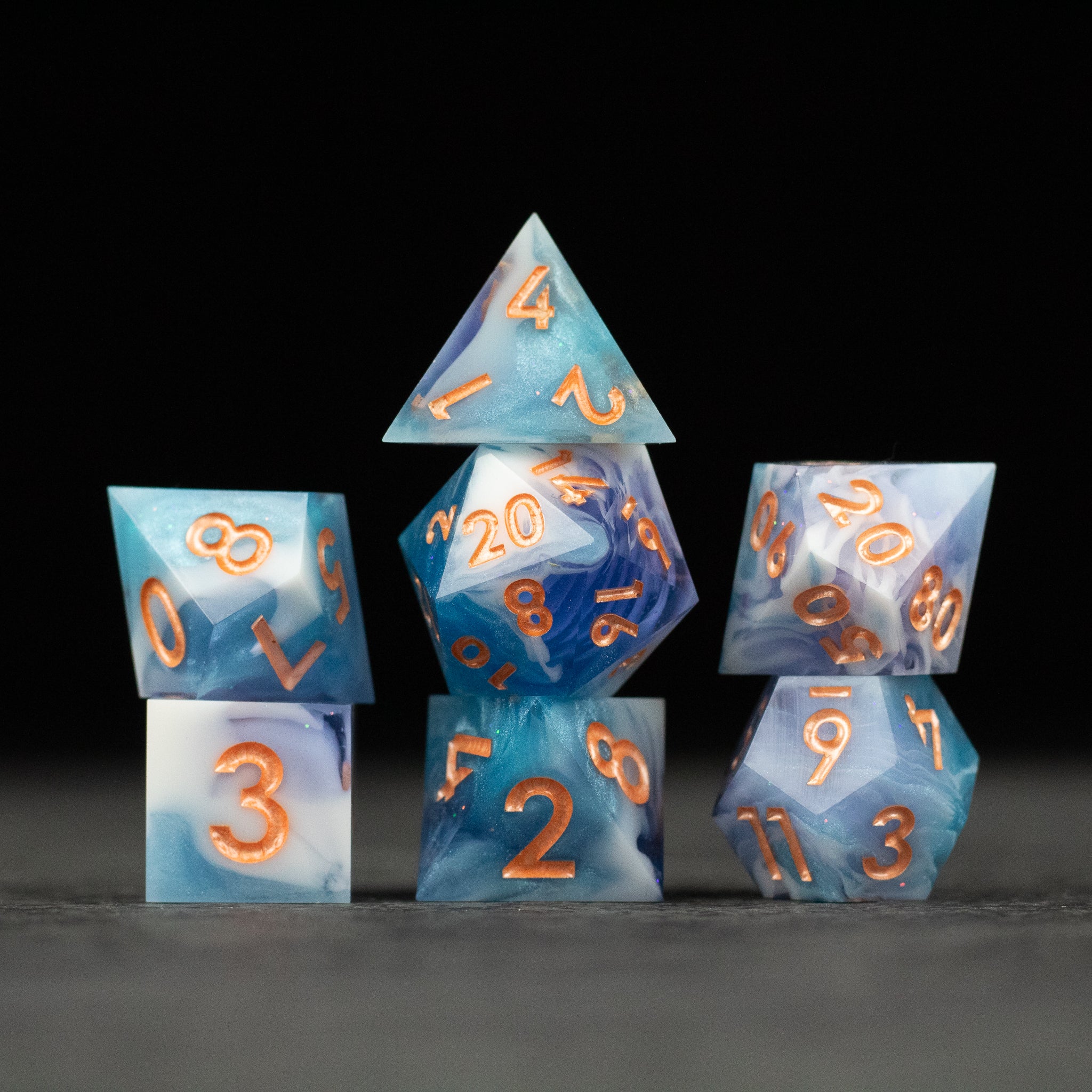 Cloudscape Dice Set - Set of blue and white marbled sharp-edge dice with orange numbers, including d20, d12, d10, d8, d6, and d4.