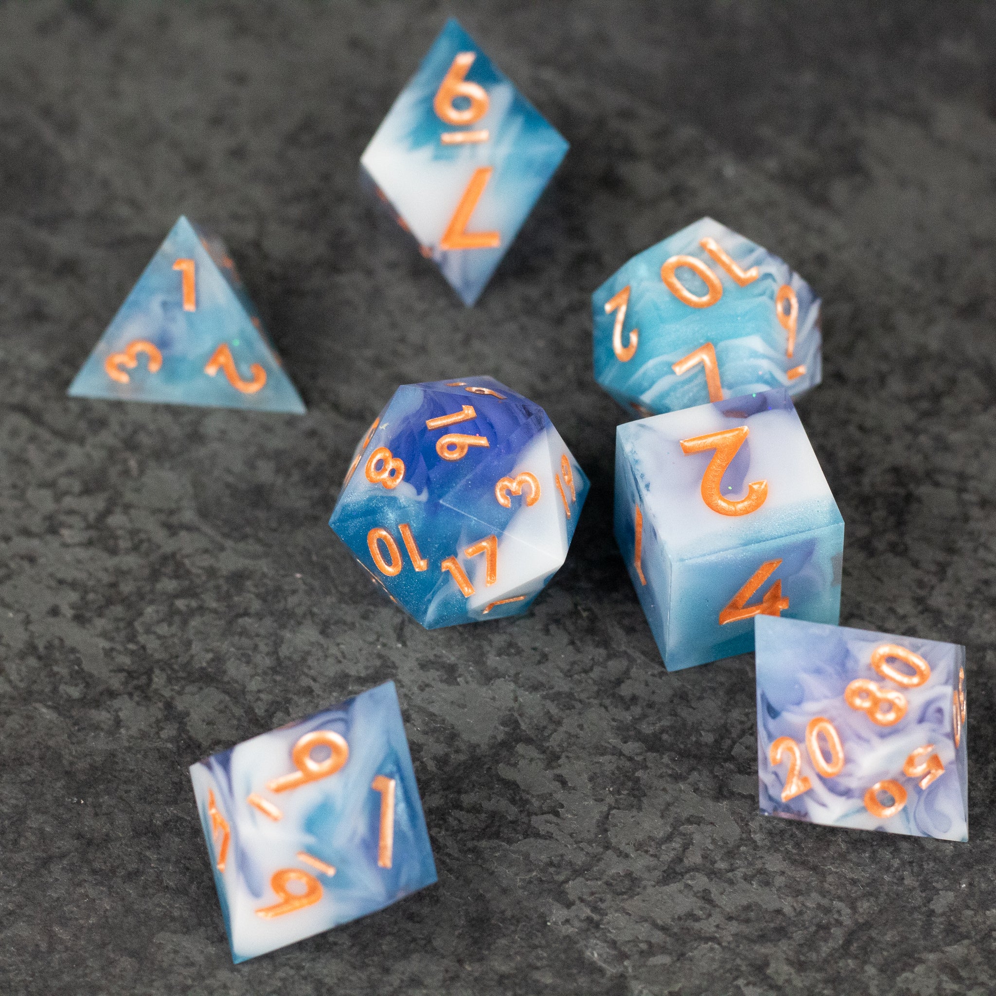 Cloudscape Dice Set - Blue and white marbled sharp-edged dice set with orange numbers, including d4, d6, d8, d10, d12, and d20.