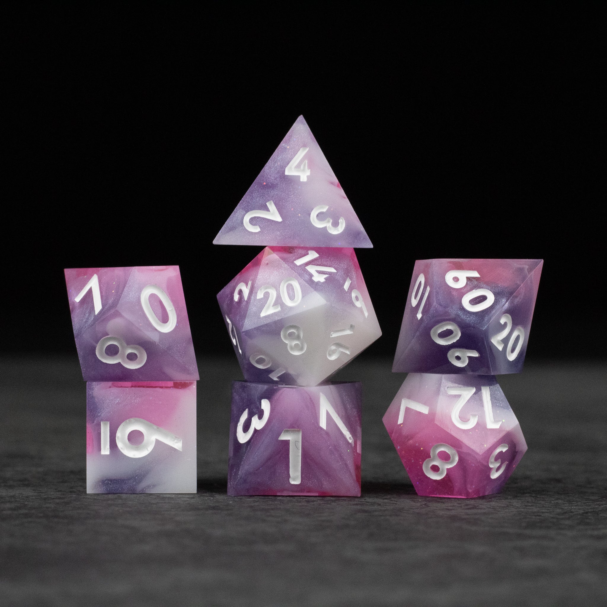 Melody Dice Set - Set of seven sharp-edged dice in pink and white gradient with white numbering.