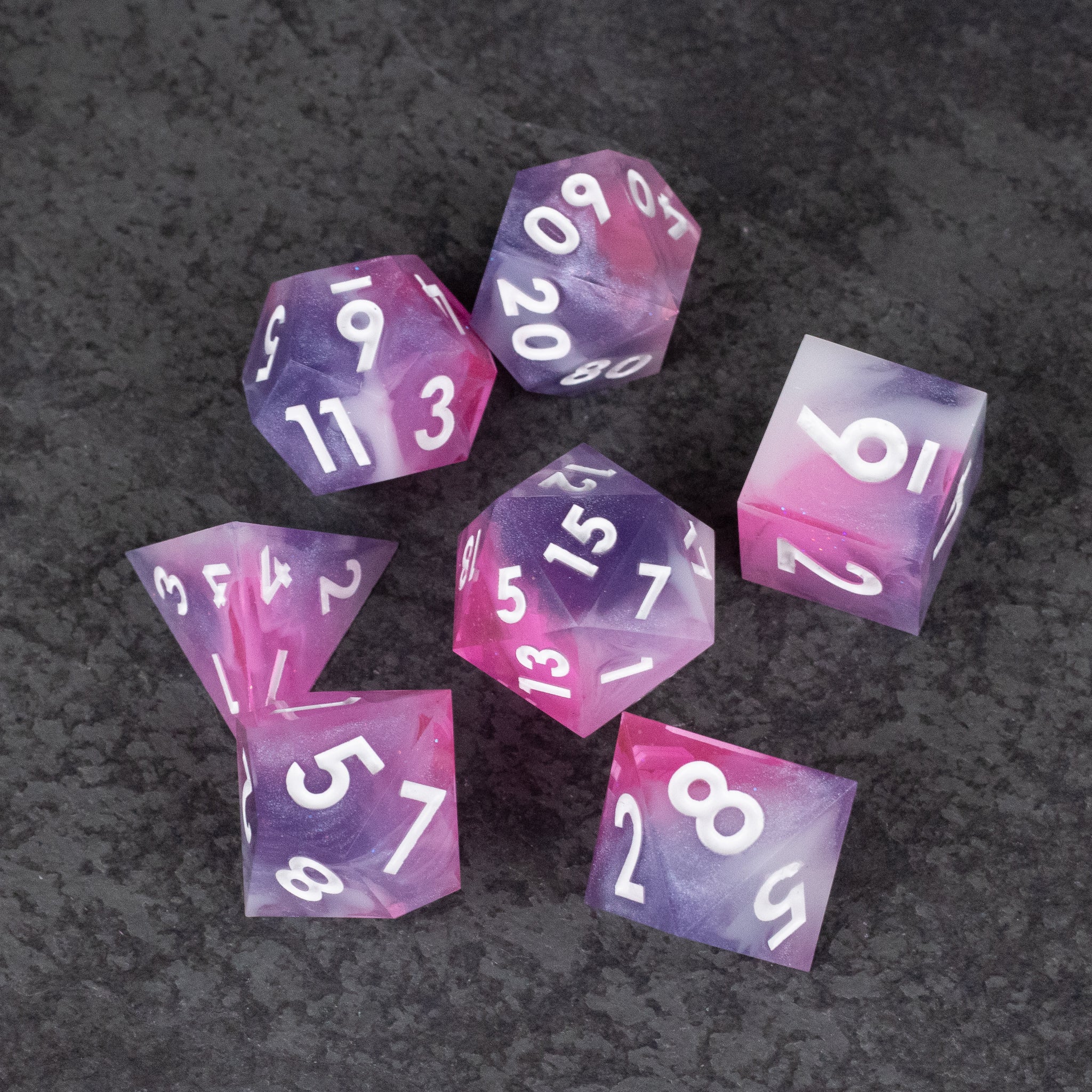Melody Dice Set - Set of seven translucent pink sharp-edged polyhedral dice with white numbers on a dark textured background.