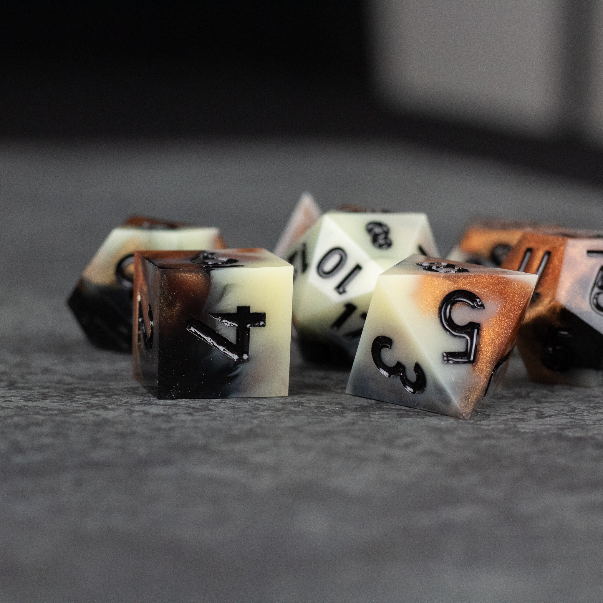 Dwarven Delight Dice Set - Set of sharp-edged dice in creamy beige and dark brown gradient with black numbers, designed for tabletop gaming.