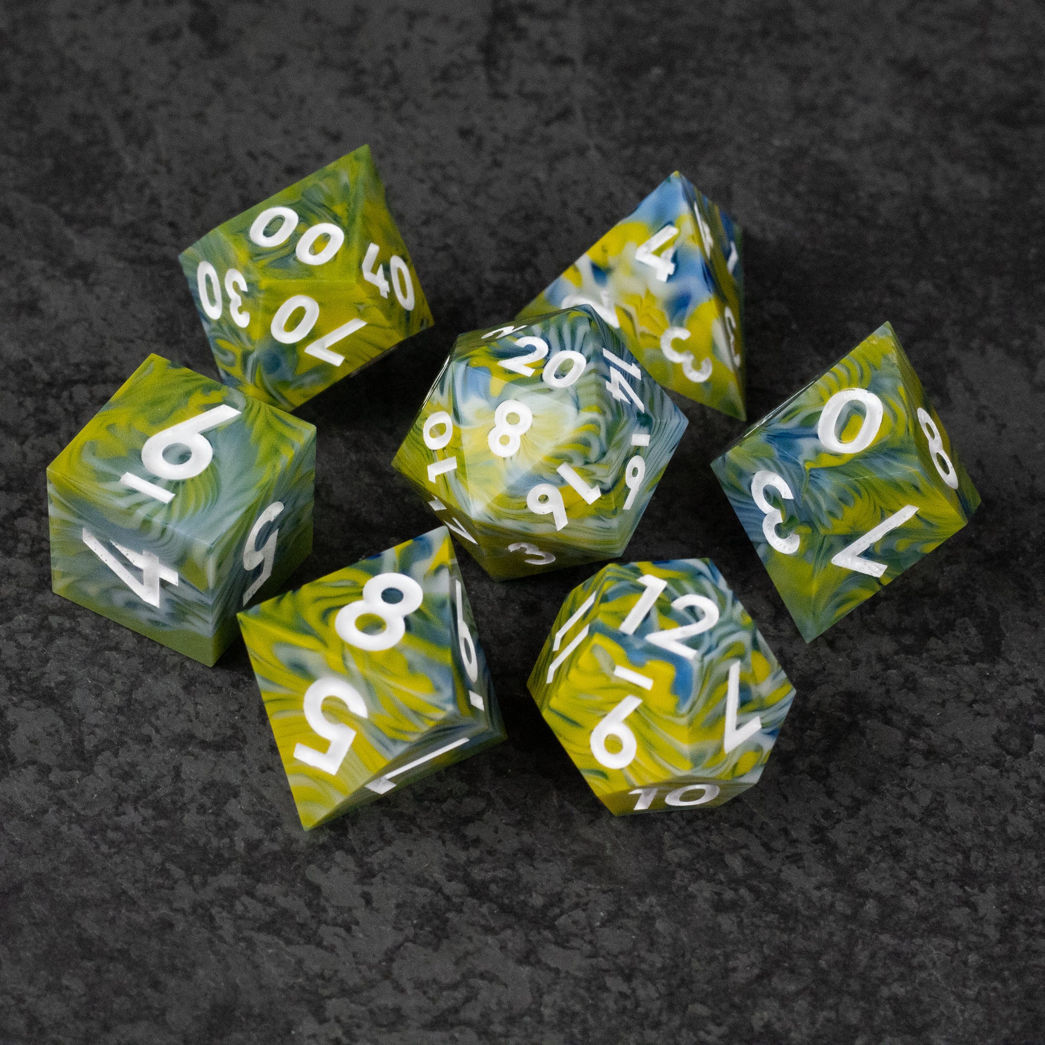 Acid Splash Dice Set - Set of seven sharp-edged polyhedral dice with green and yellow swirling patterns and white numbers.