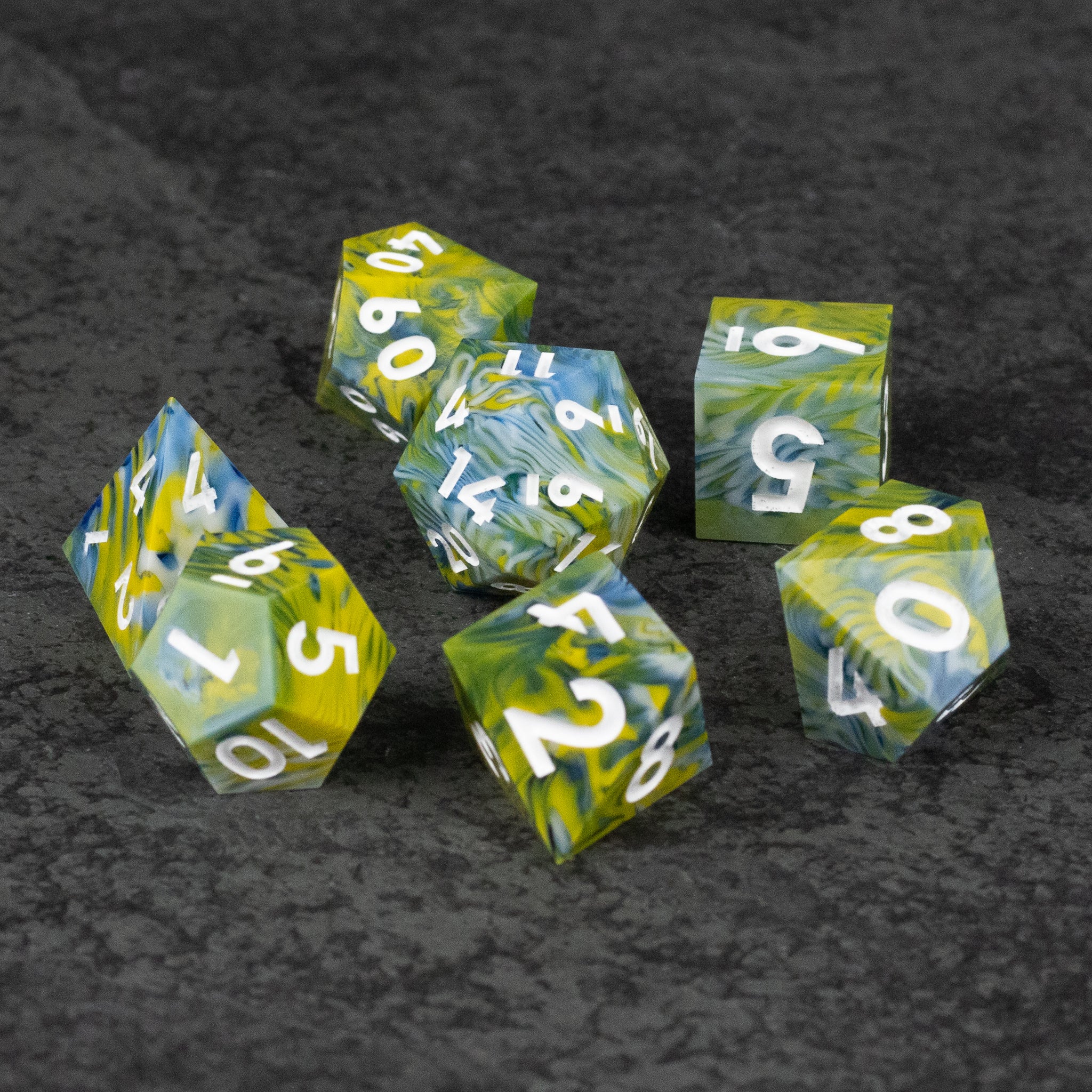 Acid Splash Dice Set - Set of seven translucent sharp-edged dice in green and yellow swirls with white numbering.