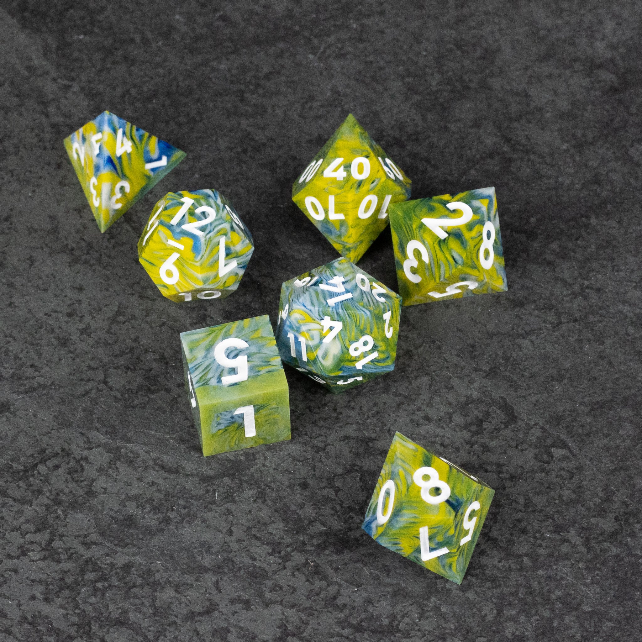 Acid Splash Dice Set - Set of seven sharp-edged green and yellow marbled dice with white numbers on a dark background.