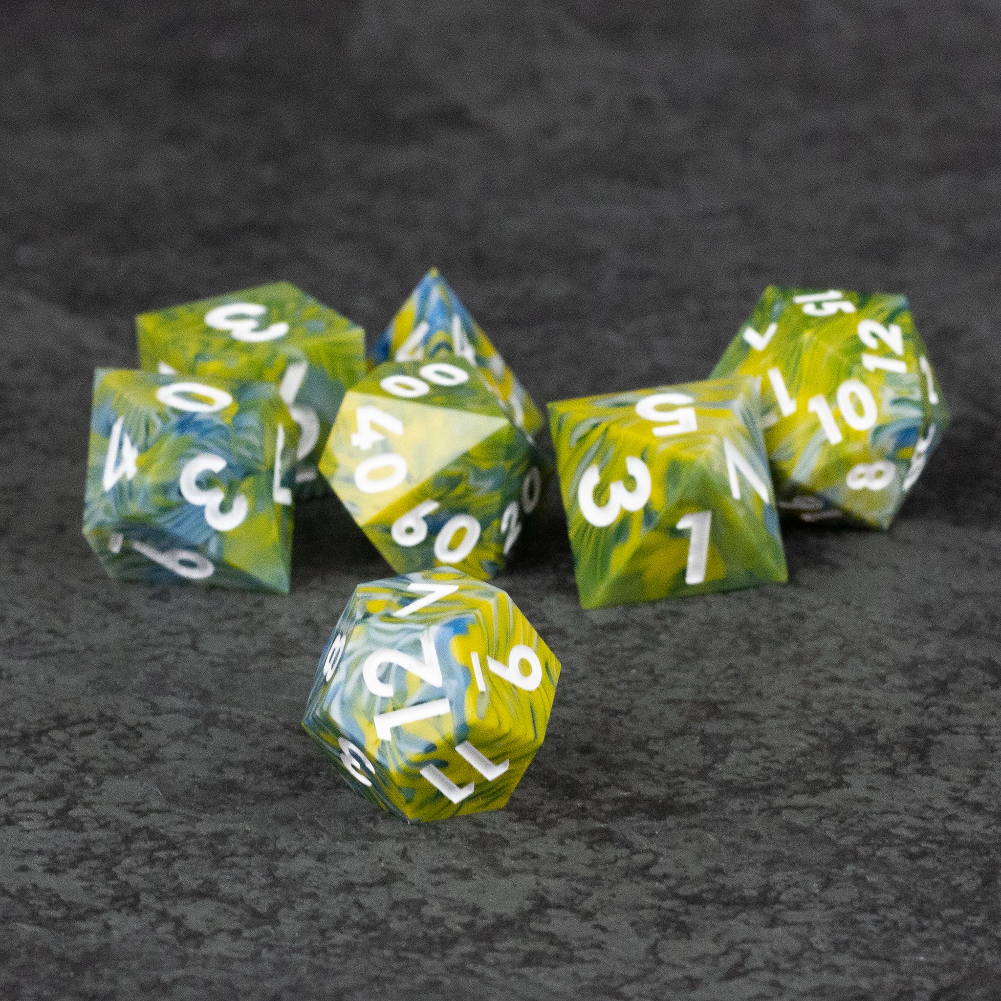 Acid Splash Dice Set - Seven green and yellow sharp-edged polyhedral dice with white numbers on a dark textured surface.