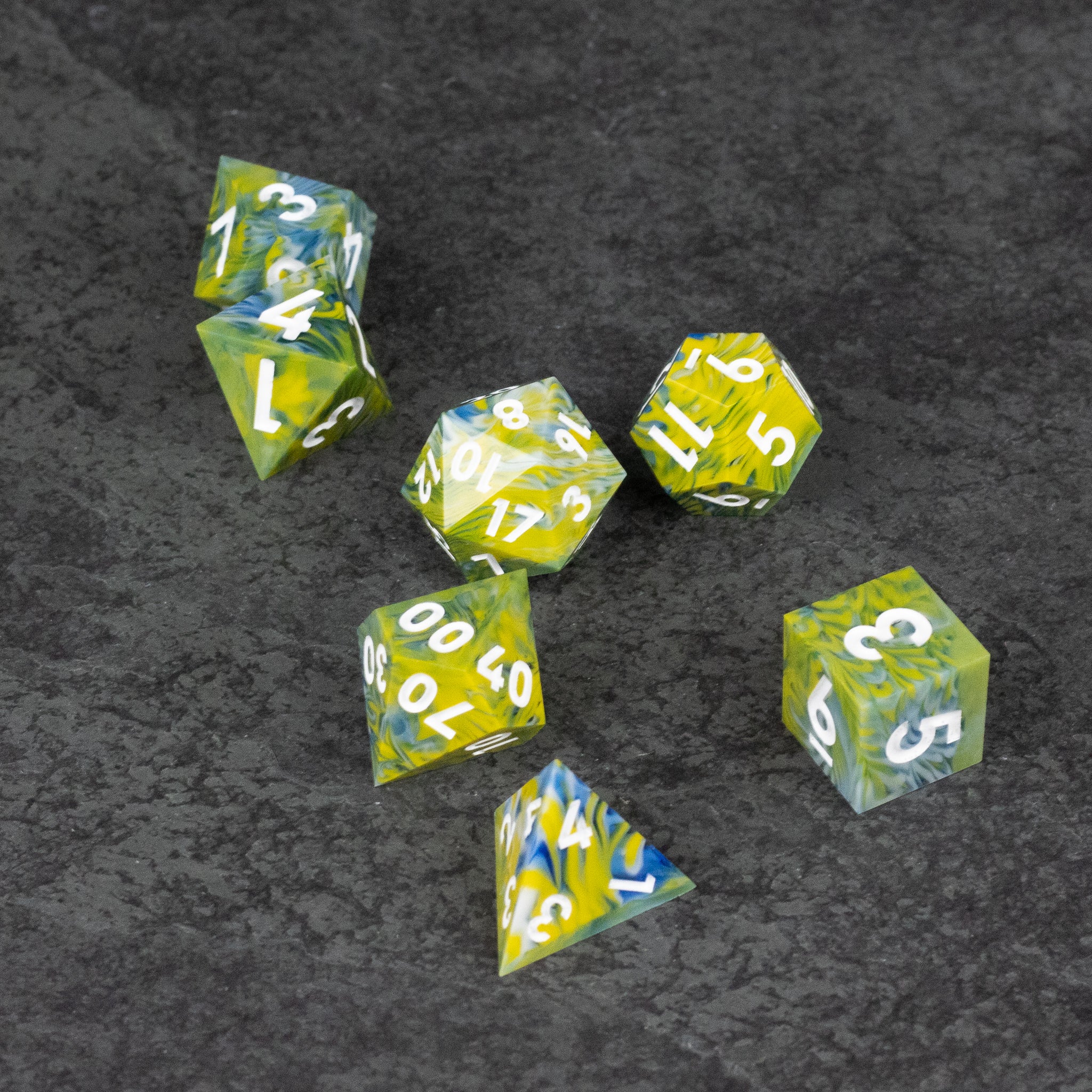 Acid Splash Dice Set - Seven sharp-edged polyhedral dice in translucent green and yellow with white numbering on a dark textured surface.