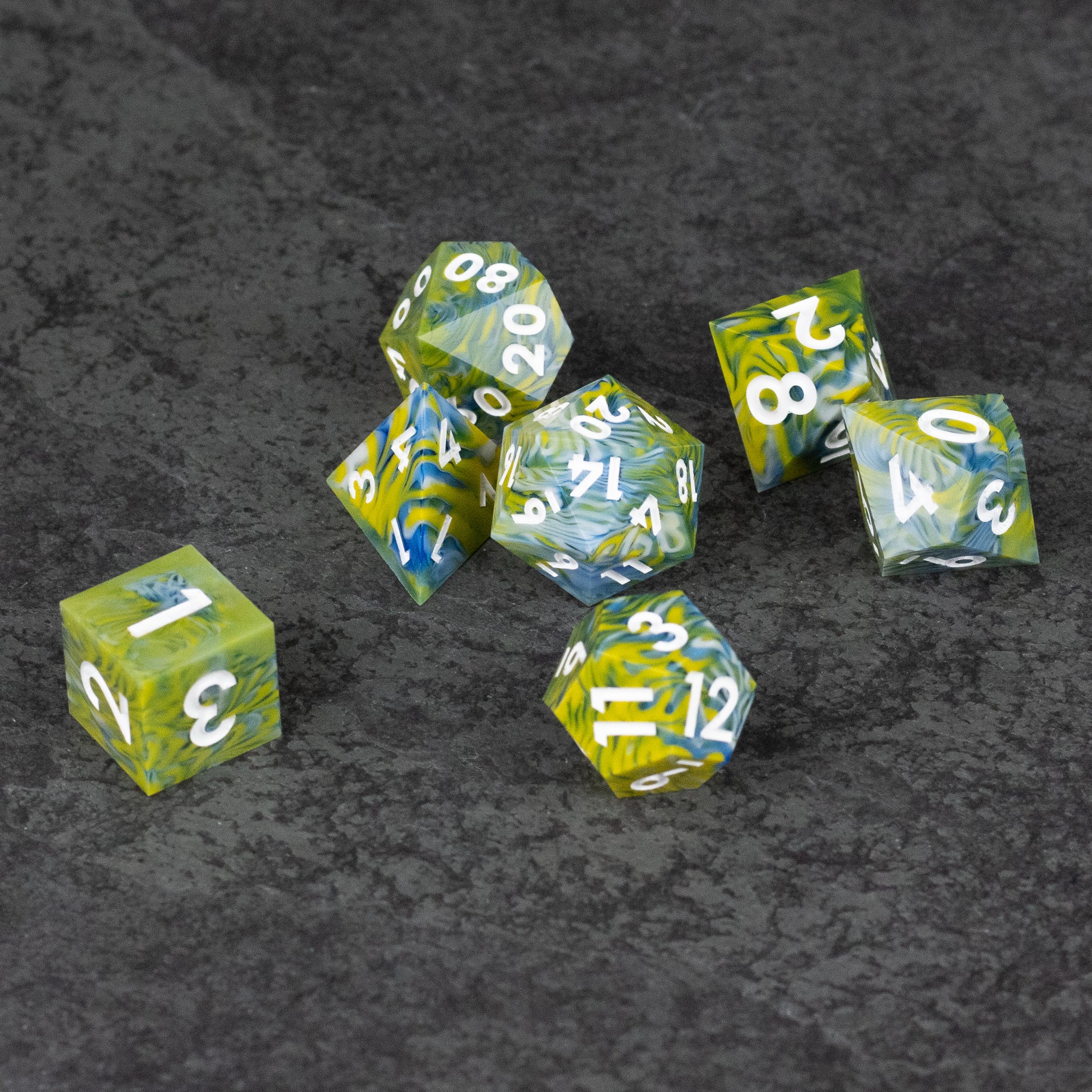 Acid Splash Dice Set - Set of transparent green and yellow sharp-edged polyhedral dice with white numbers on black textured background.