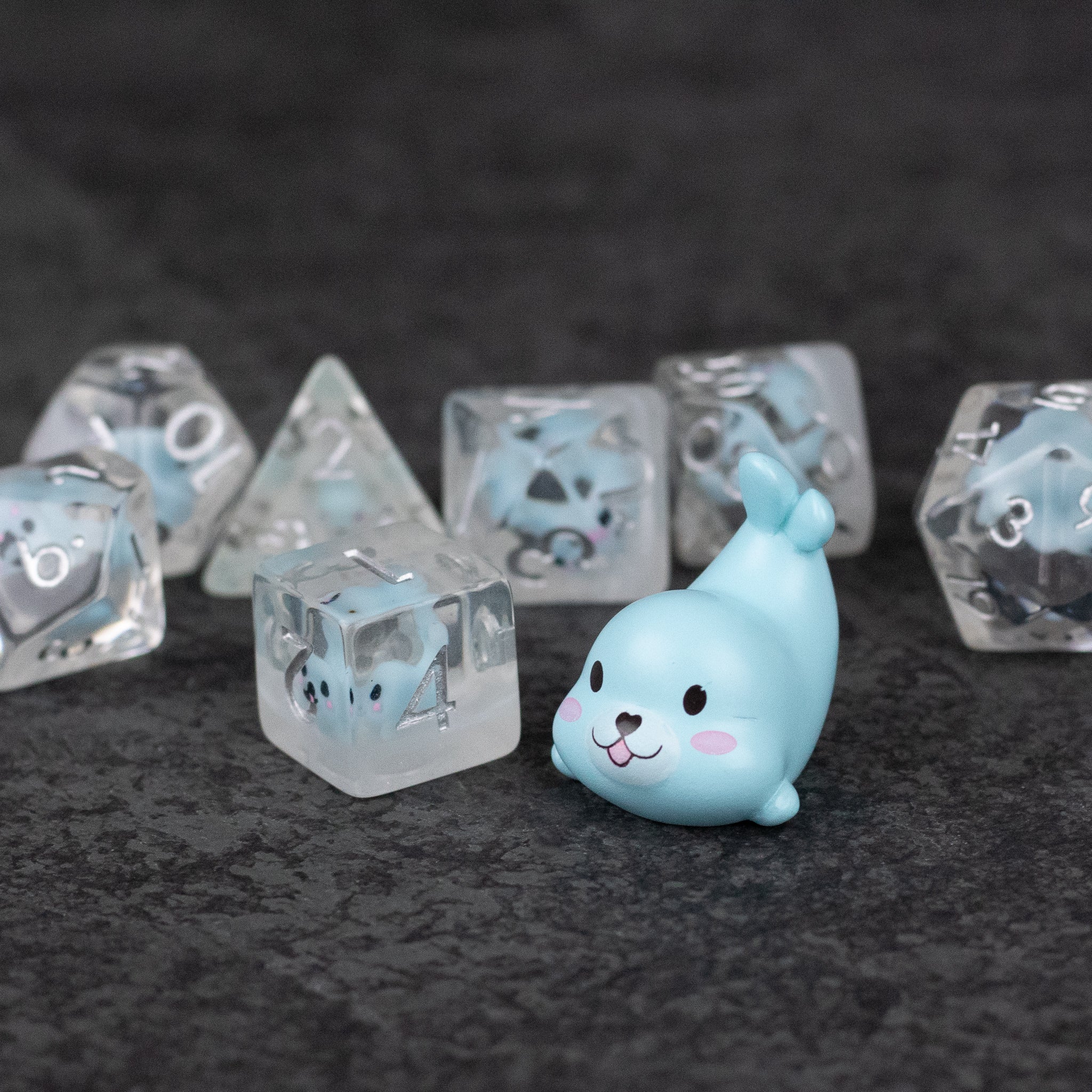 Blue Seal Dice Set - Clear dice with blue seal illustrations and a blue seal figurine on dark surface.