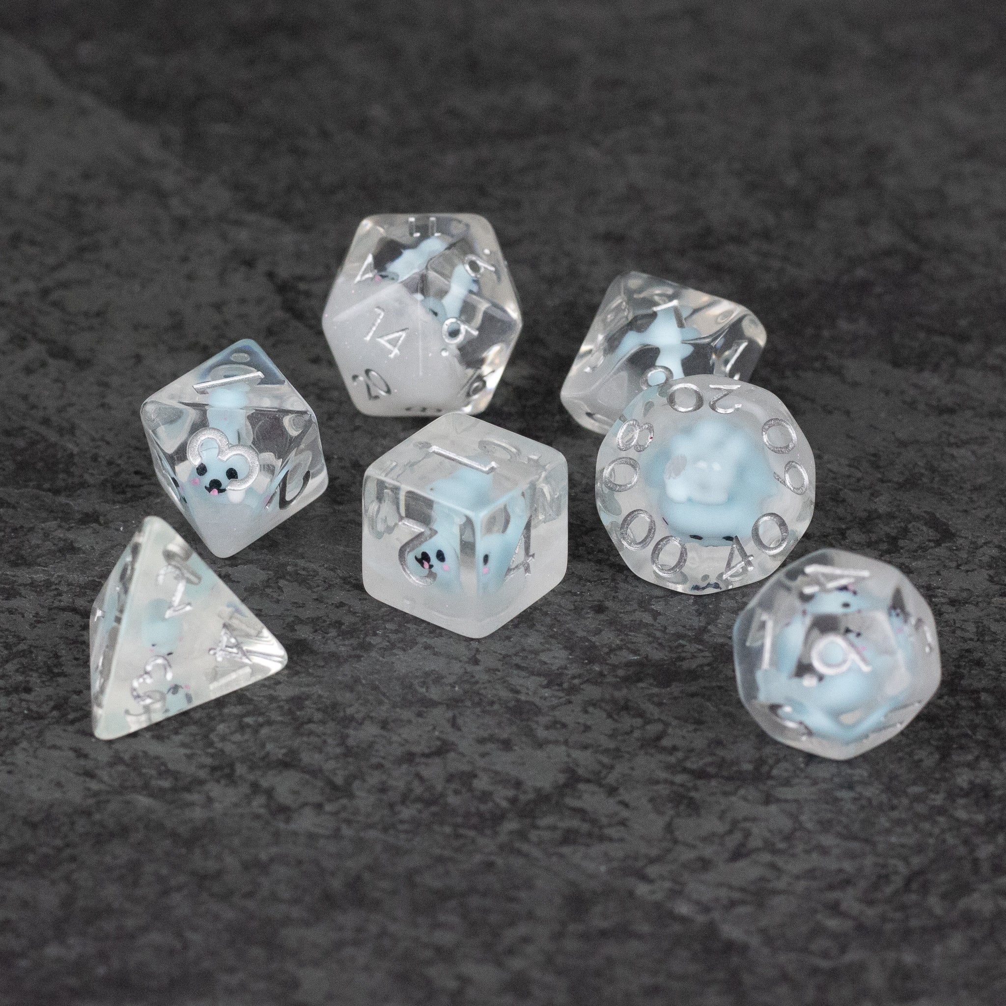 Blue Seal Dice Set - Translucent blue seven-piece dice set with seal faces and white numbering on black surface.