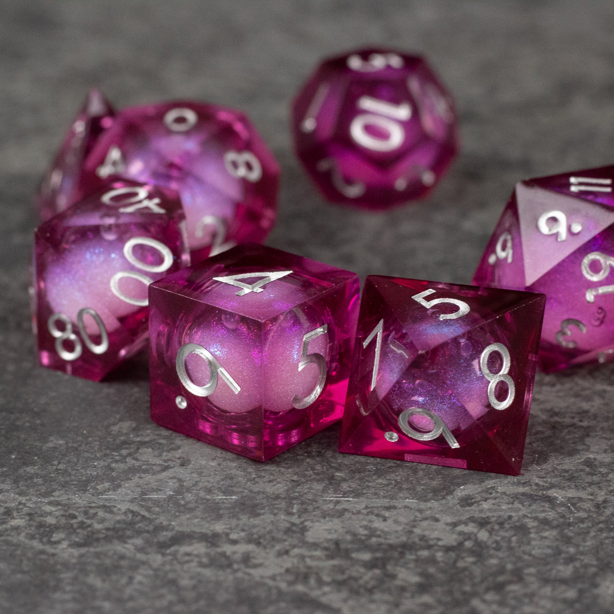 Magic Wine - Liquid Core Dice Set - Set of six translucent red polyhedral dice with sharp edges and swirling liquid cores, white numbering.