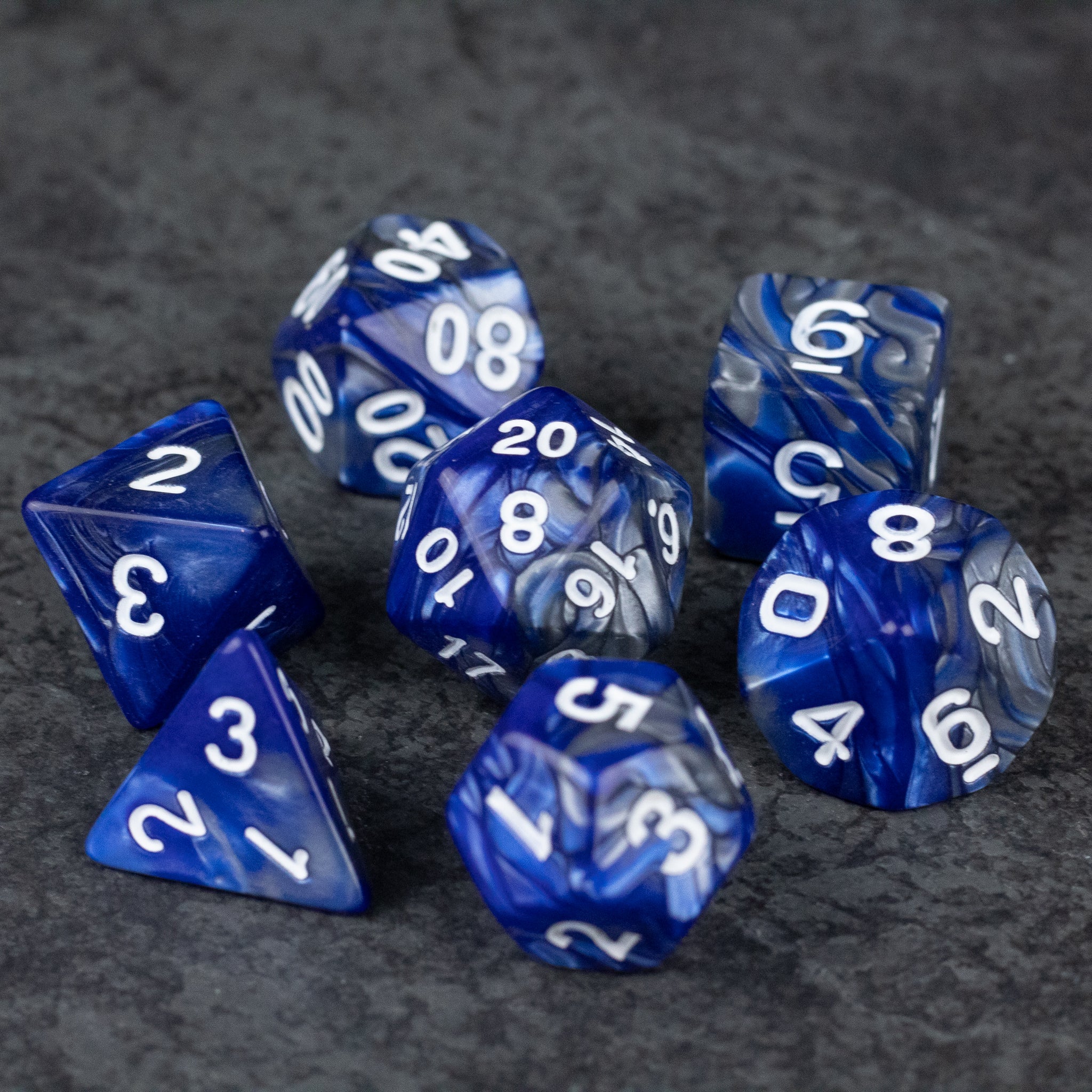 Royal Blue and Silver Acrylic Dice Set - Set of seven royal blue acrylic dice with white numbers, including d4, d6, d8, d10, d12, d20, and percentile dice.