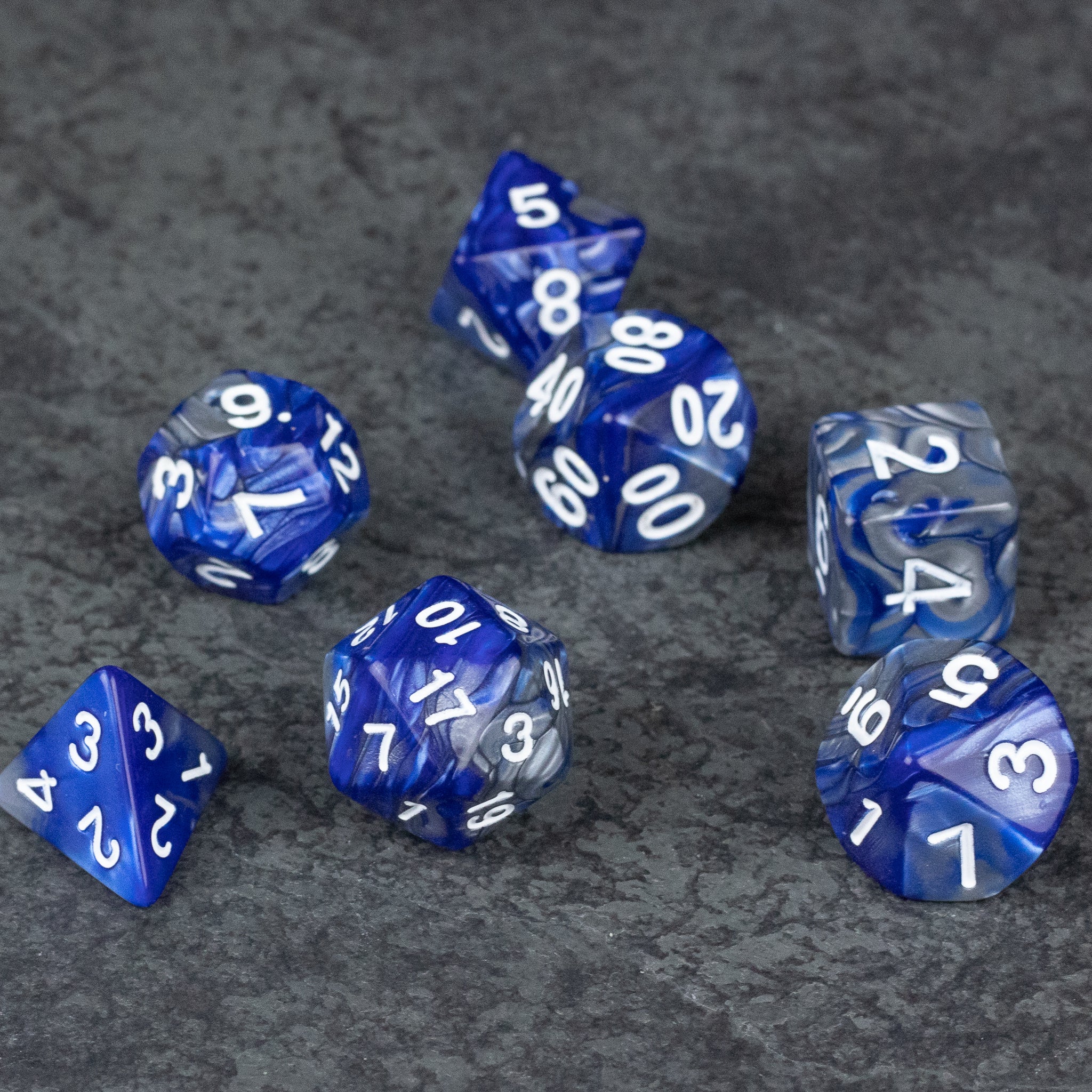Royal Blue and Silver Acrylic Dice Set - Royal blue acrylic dice set with white numbering, including d4, d6, d8, d10, d12, and d20 shapes on gray background.