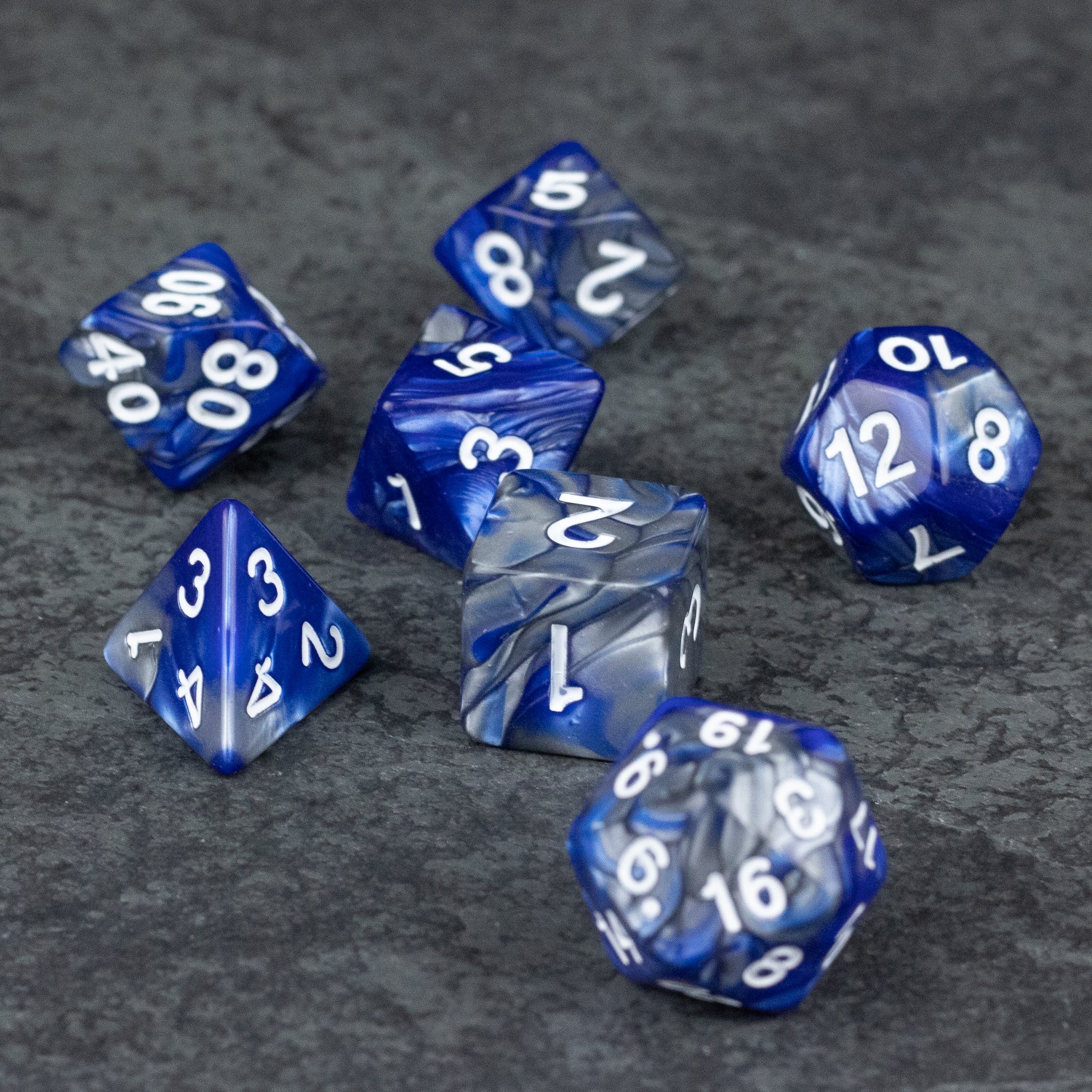 Royal Blue and Silver Acrylic Dice Set - Set of seven royal blue and clear acrylic dice with white numbering, including d4, d6, d8, d10, percentile, d12, and d20.