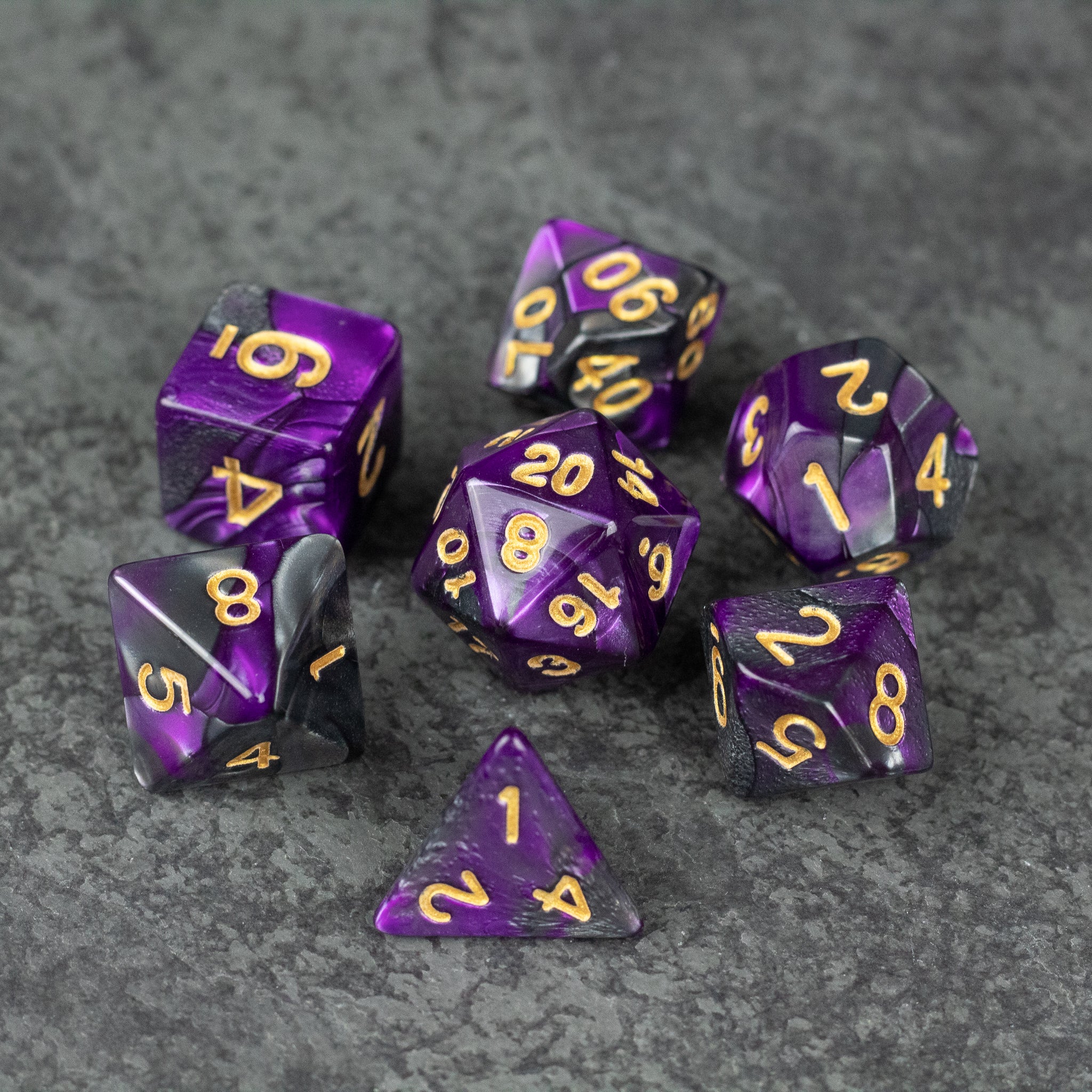 Purple and Black Marbled Dice Set - Set of seven purple and black marbled acrylic dice with gold numbering on gray textured surface.