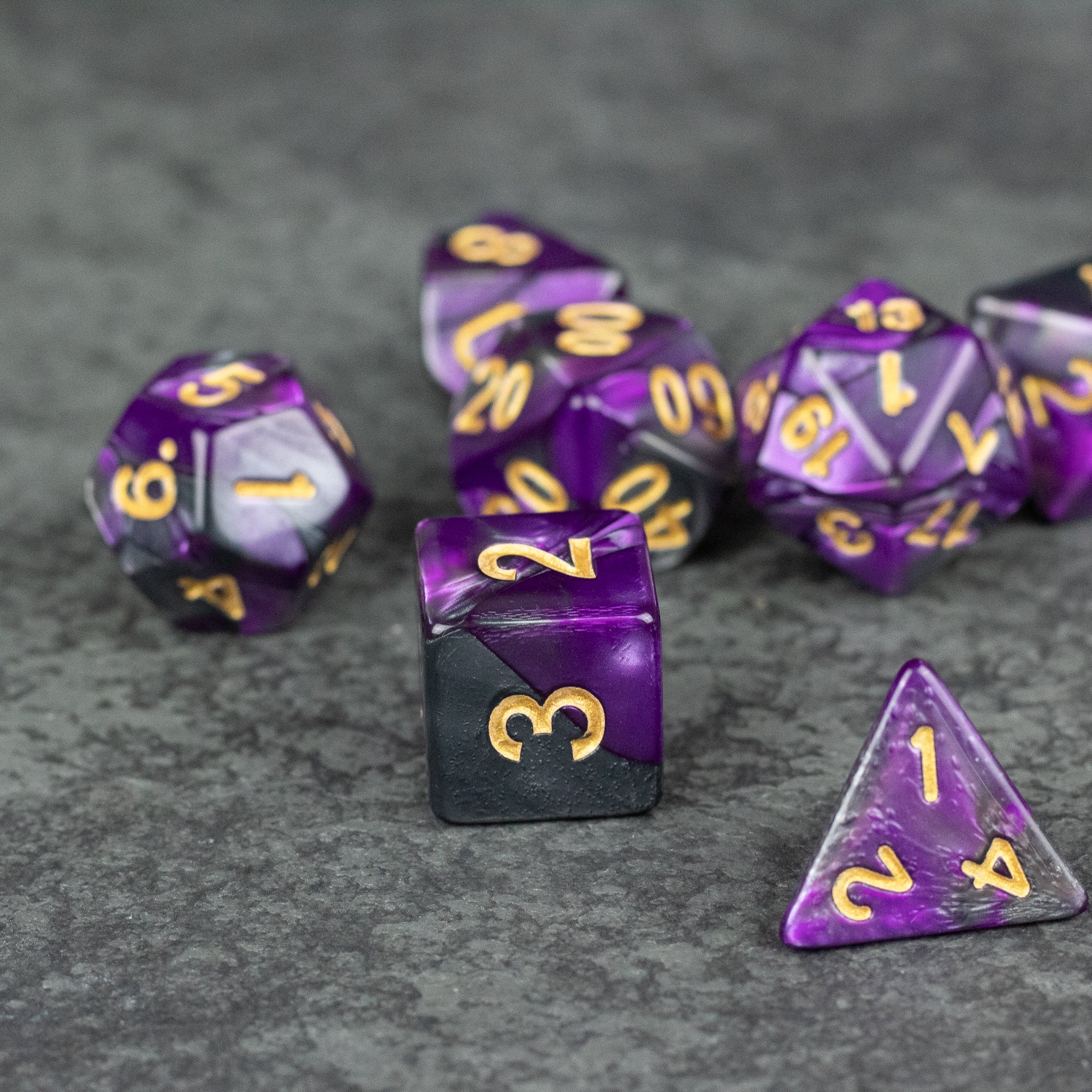 Purple and Black Marbled Dice Set - Set of acrylic dice featuring a purple and black marbled pattern with gold numbering.