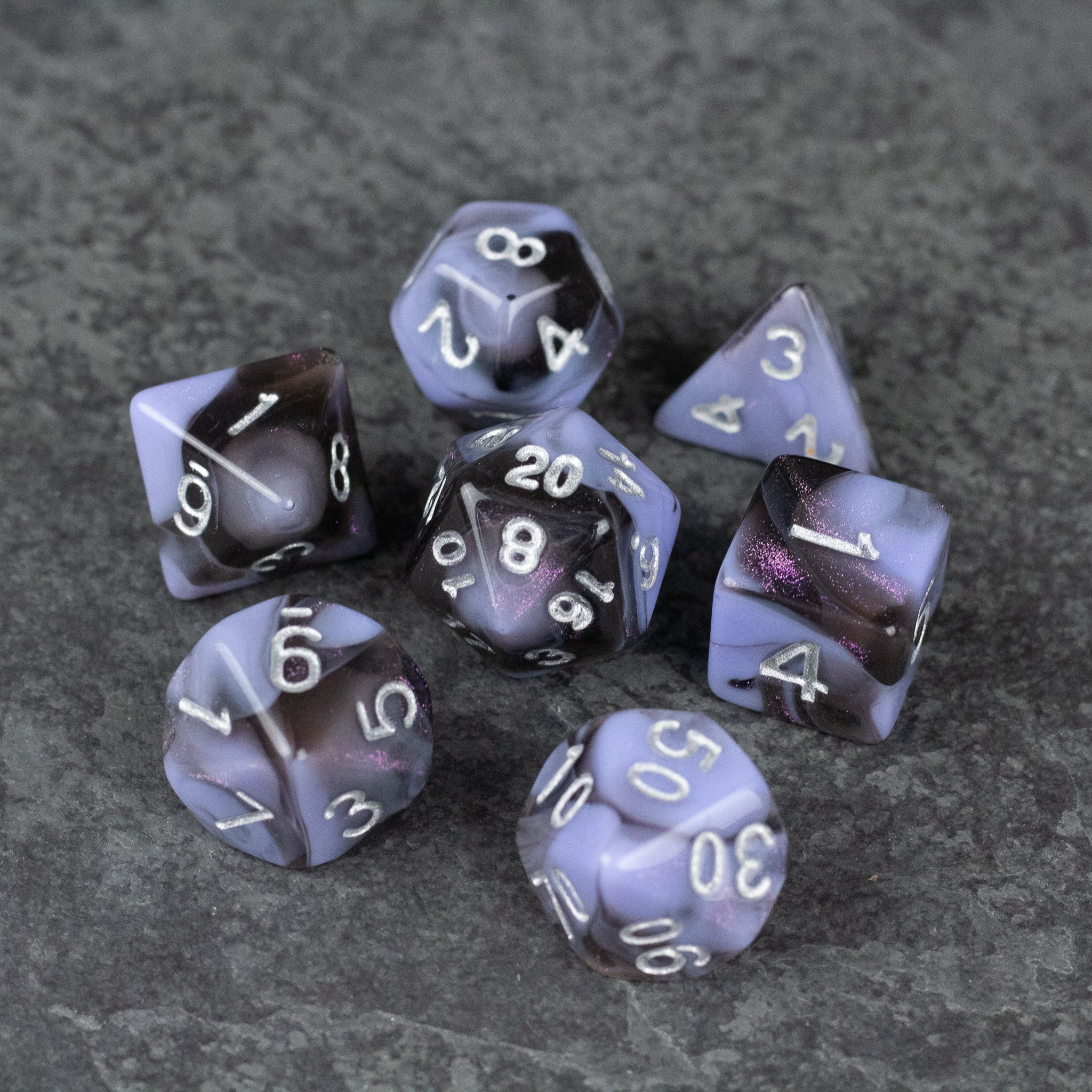 Periwinkle and Black Marbled Dice Set - Periwinkle and black marbled acrylic dice set with white numbering on dark textured background.