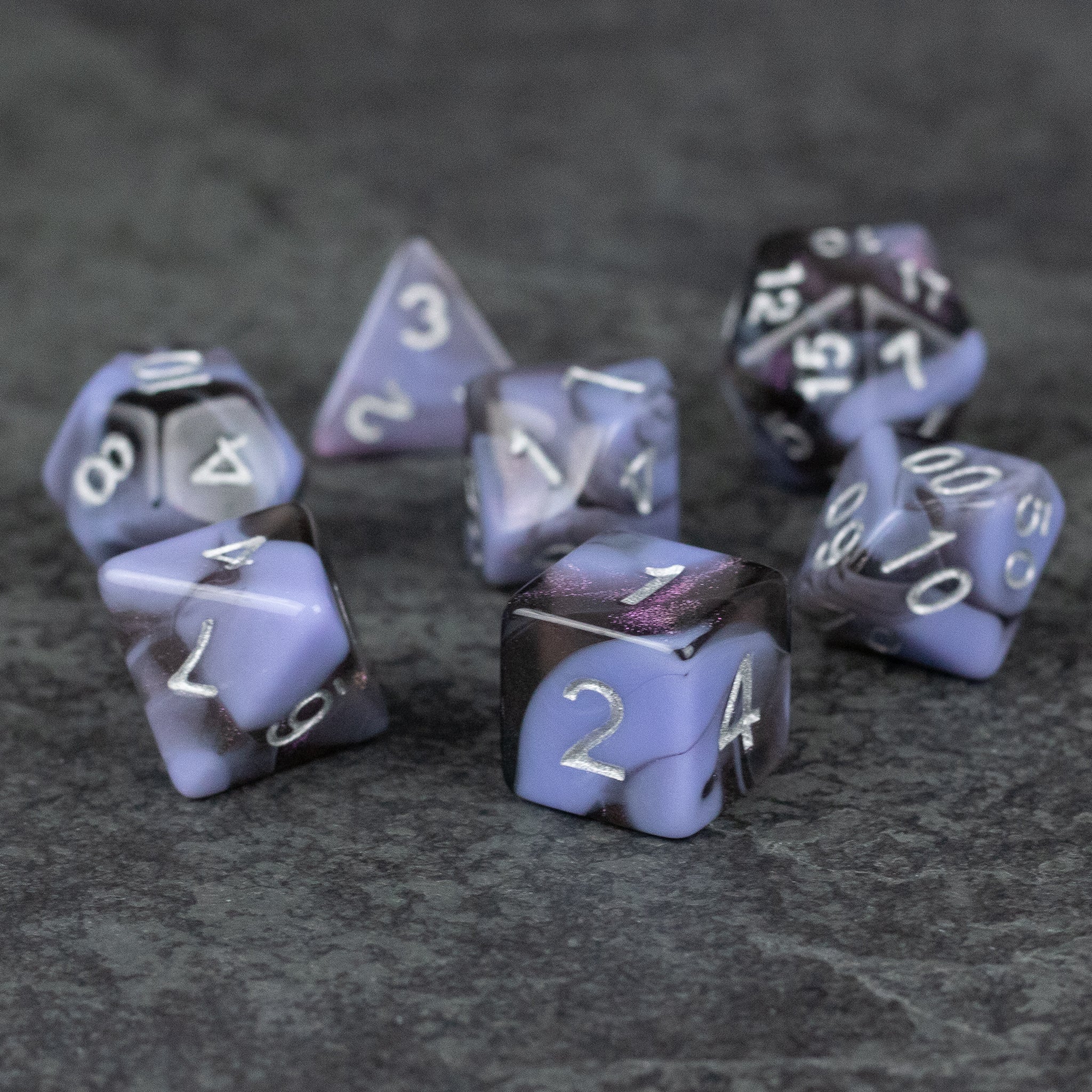 Periwinkle and Black Marbled Dice Set - Seven acrylic octahedron, cube, and polyhedral dice with marbled periwinkle and black patterns and white numbering.