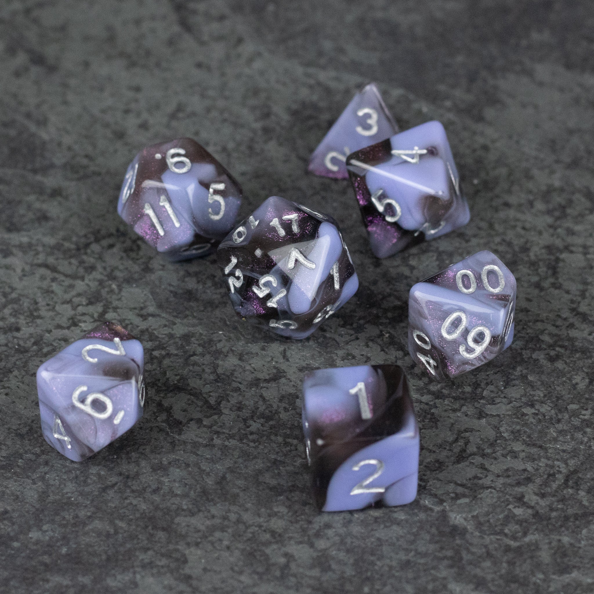 Periwinkle and Black Marbled Dice Set - Set of seven acrylic dice with marbled periwinkle and black patterns, white numbers visible on each die.