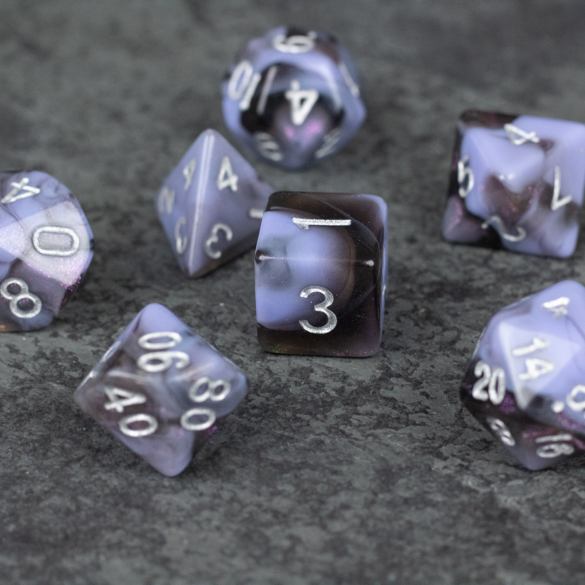 Periwinkle and Black Marbled Dice Set - Set of acrylic dice with marbled periwinkle and black colors featuring white numbering.