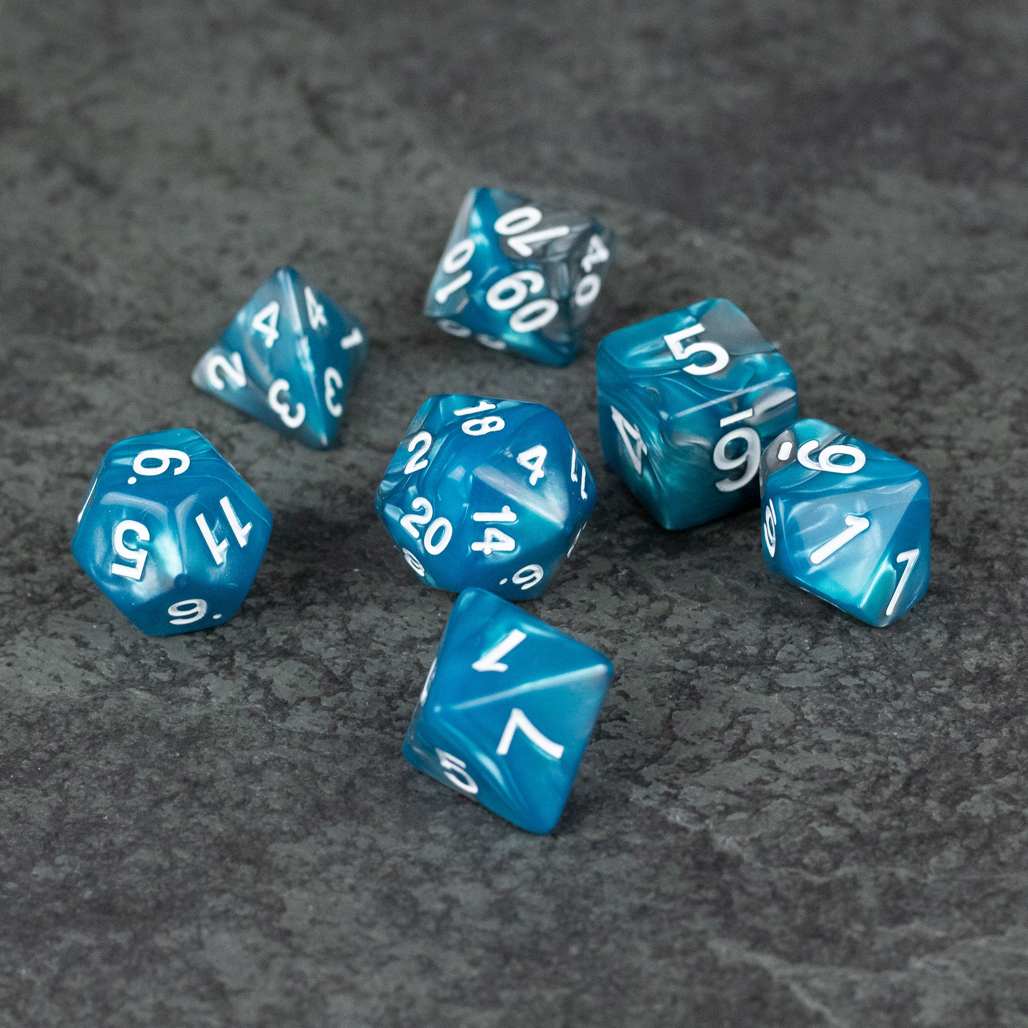 Blue and Gray Marbled Dice - Set of seven blue and gray marbled acrylic polyhedral dice with white numbers.