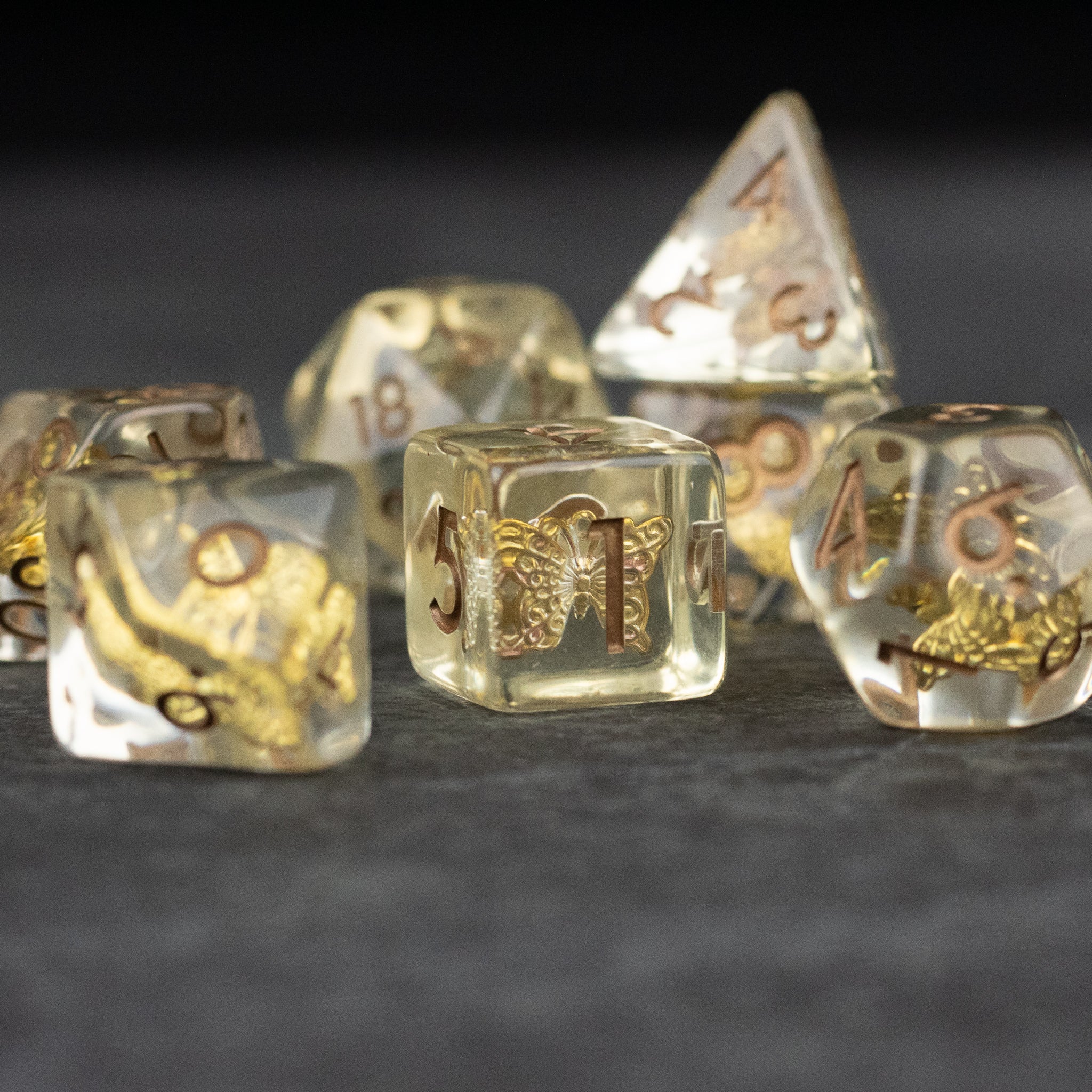 Gold Charm Butterfly Dice Set - Transparent dice set with gold butterfly charms and gold numbering on each die.