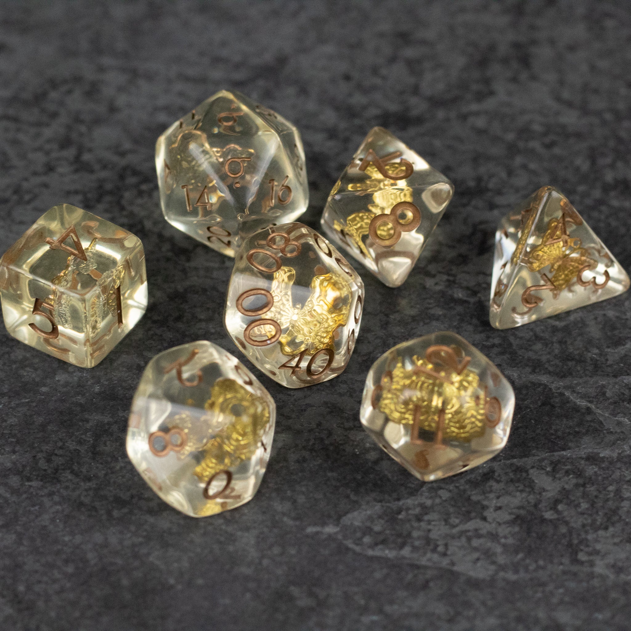 Gold Charm Butterfly Dice Set - Transparent dice set with gold butterfly charms and gold numbered details on each face.