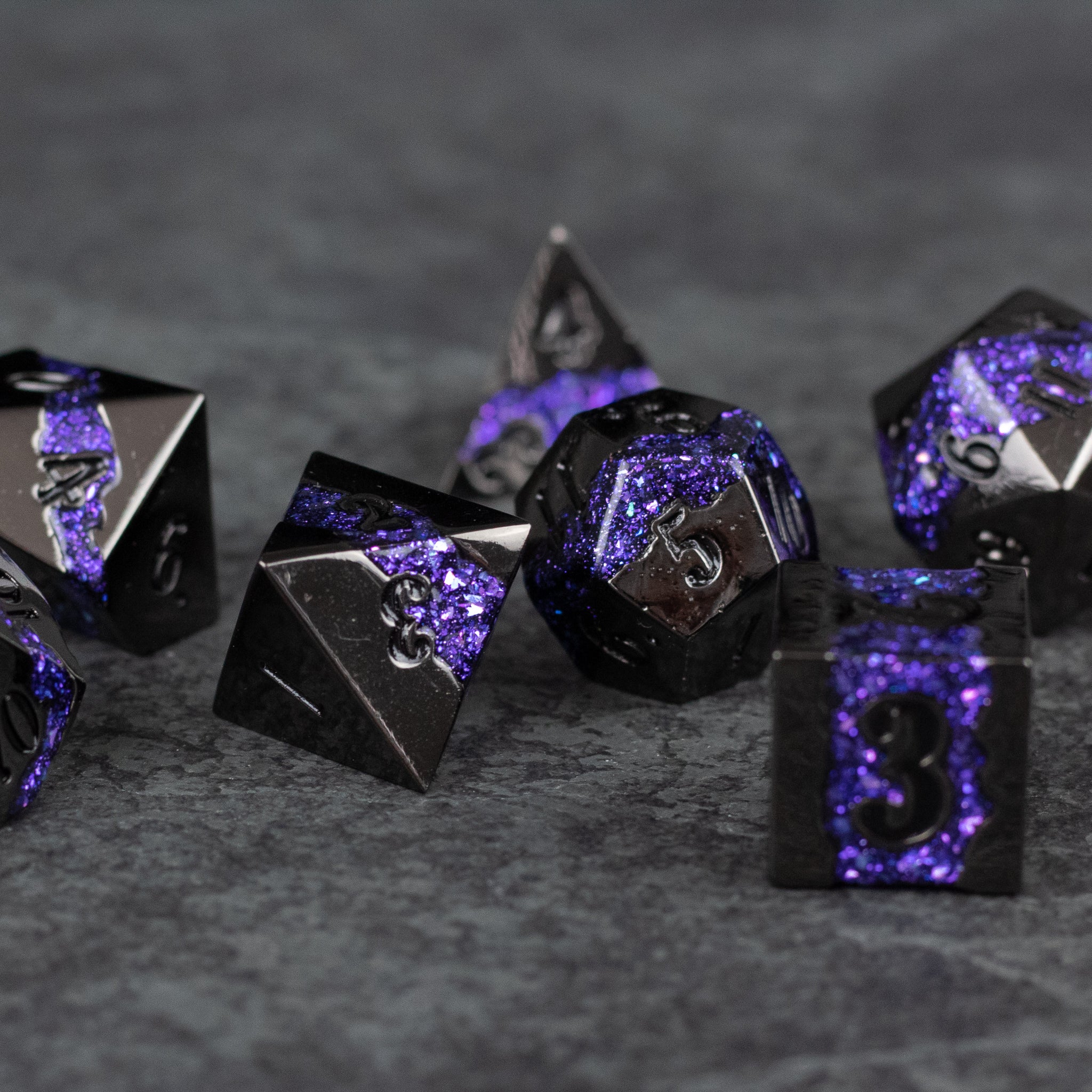 Purple Rift Dice Set - Set of seven black metal polyhedral dice with purple crackled inlays and silver numbers for tabletop gaming.