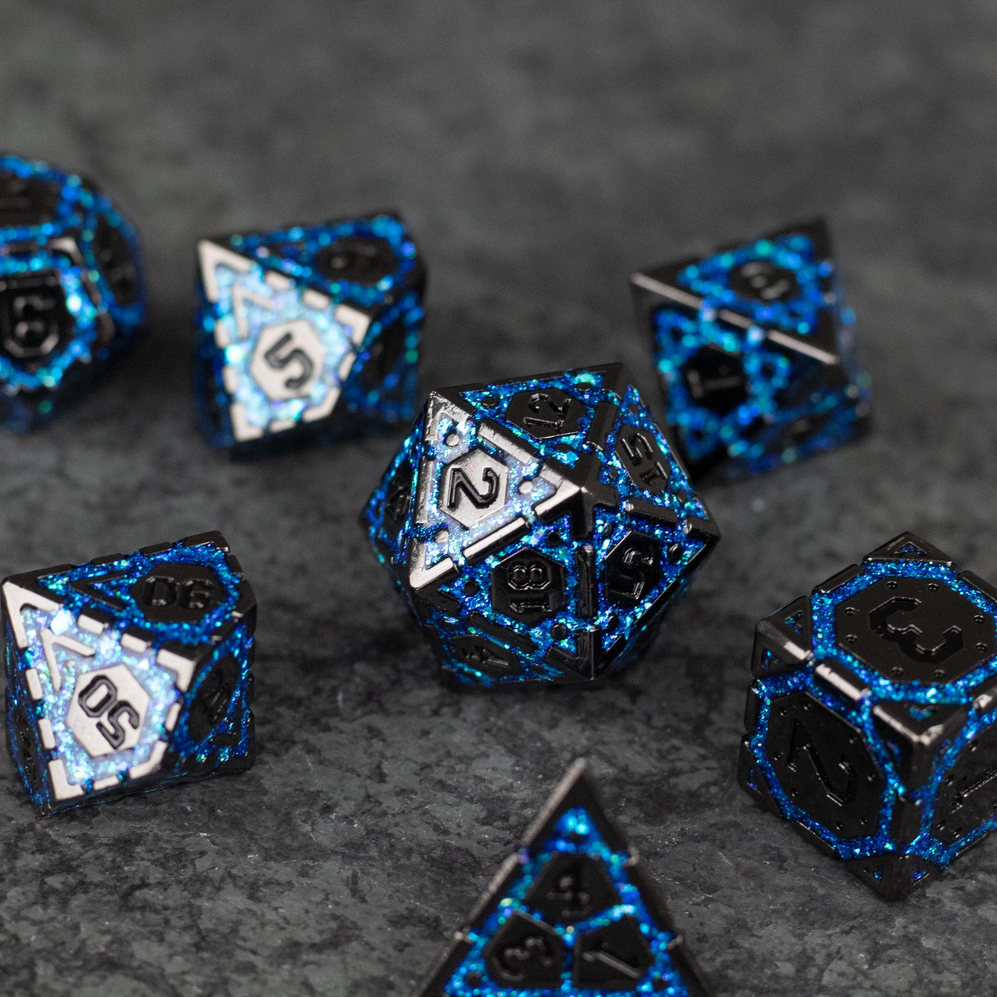 Blue Arcane Ward - Set of black metal polyhedral dice with electric blue arcane symbols and edging on textured gray background.