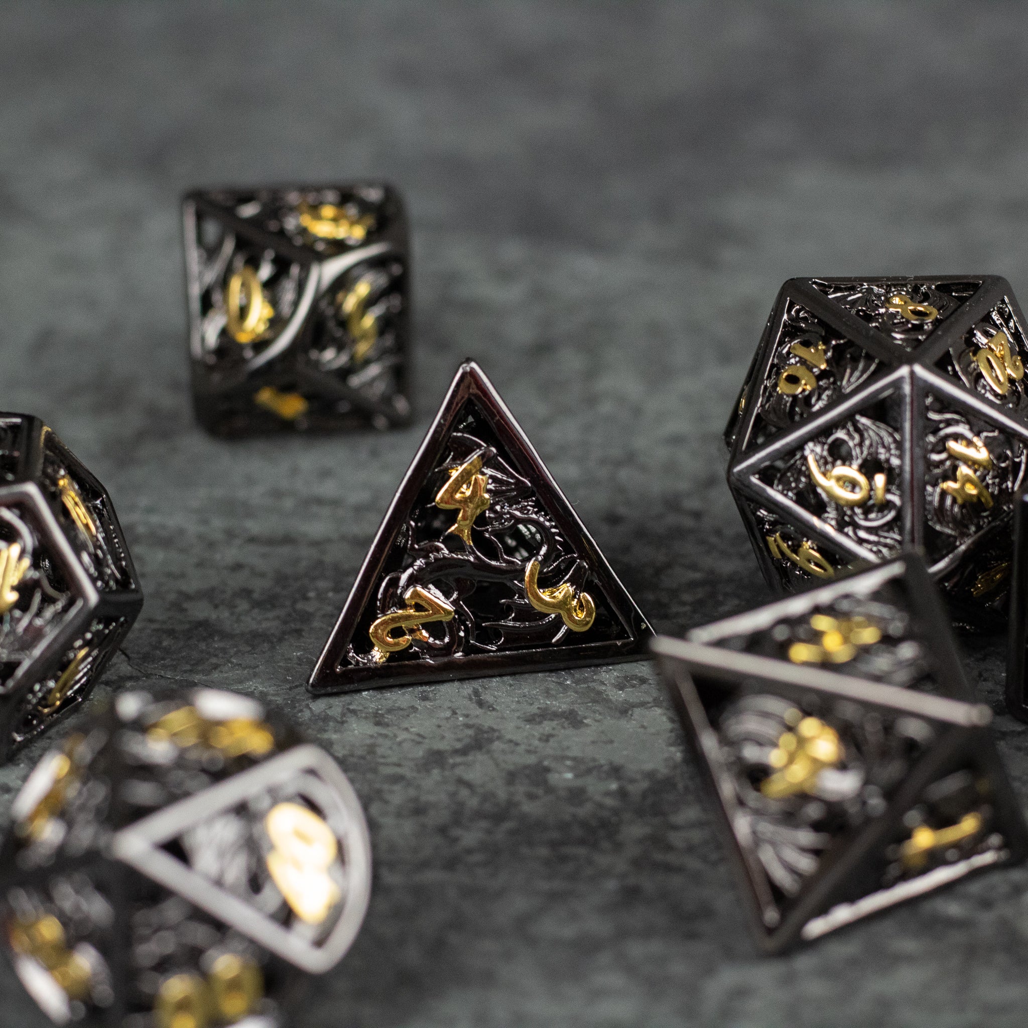 Black and Gold Dragon Hollow Dice Set - Black metal hollow dice set with intricate gold dragon designs on each face.