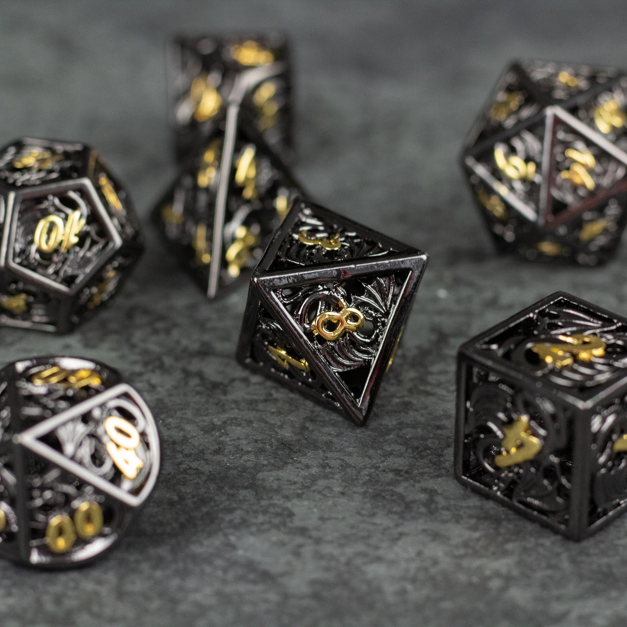 Black and Gold Dragon Hollow Dice Set - Black metal hollow dice set with intricate gold dragon designs and numbers on each face.
