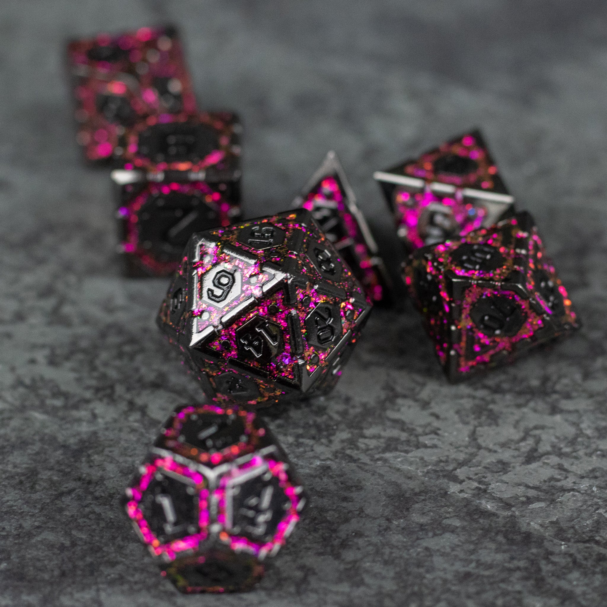 Pink Arcane Ward - Set of metallic dice with black and pink marbled finish, intricate pink numbers, and multiple polygon shapes on a stone.