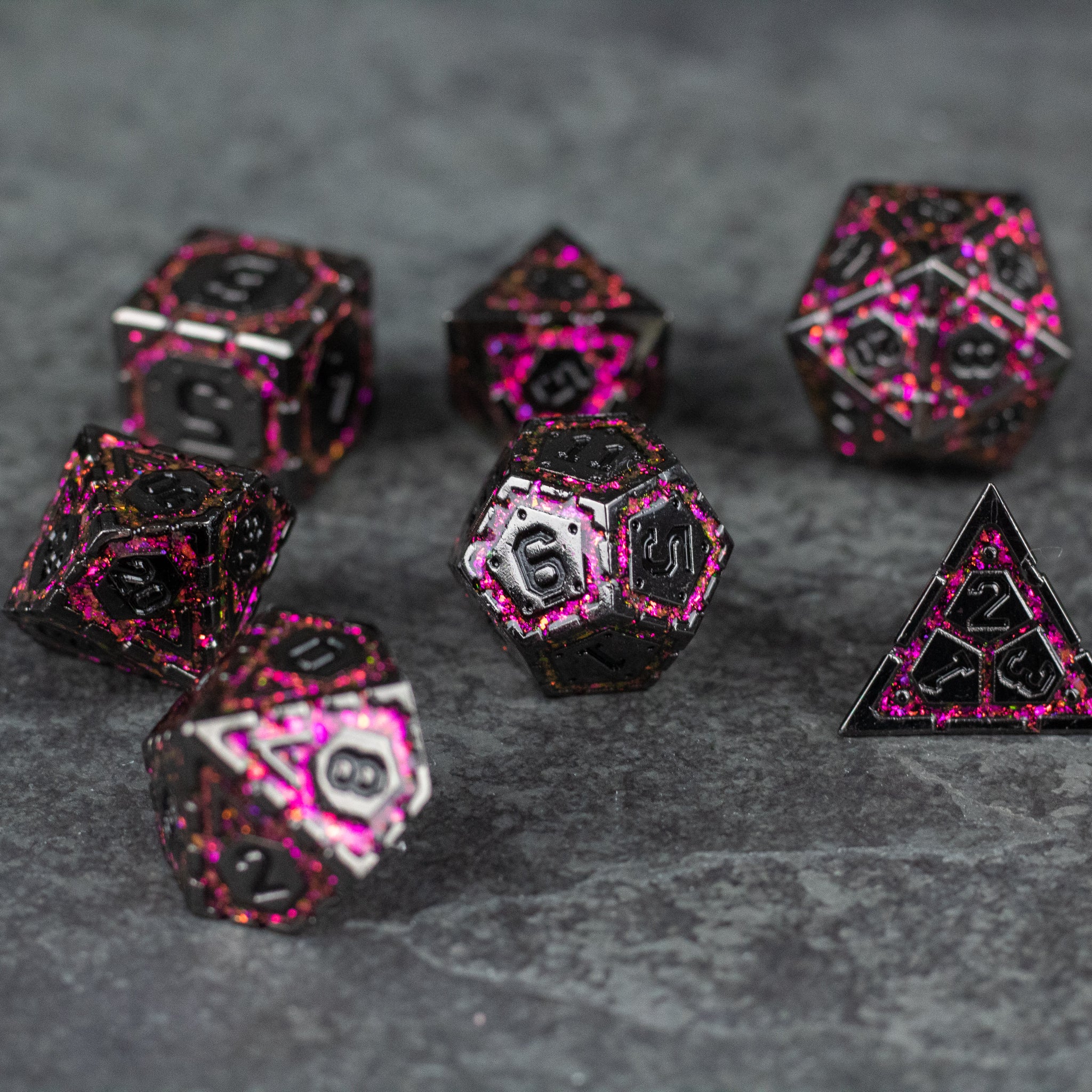 Pink Arcane Ward - Set of seven metal polyhedral dice with black base and bright pink speckled pattern, designed for fantasy tabletop gaming.