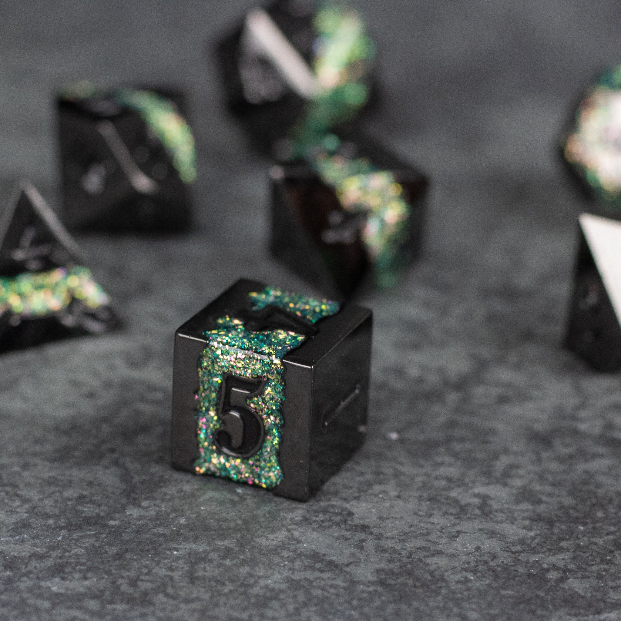 Light Green Rift Dice Set - Black metal dice with light green glitter-filled numbers and edges on a dark surface.