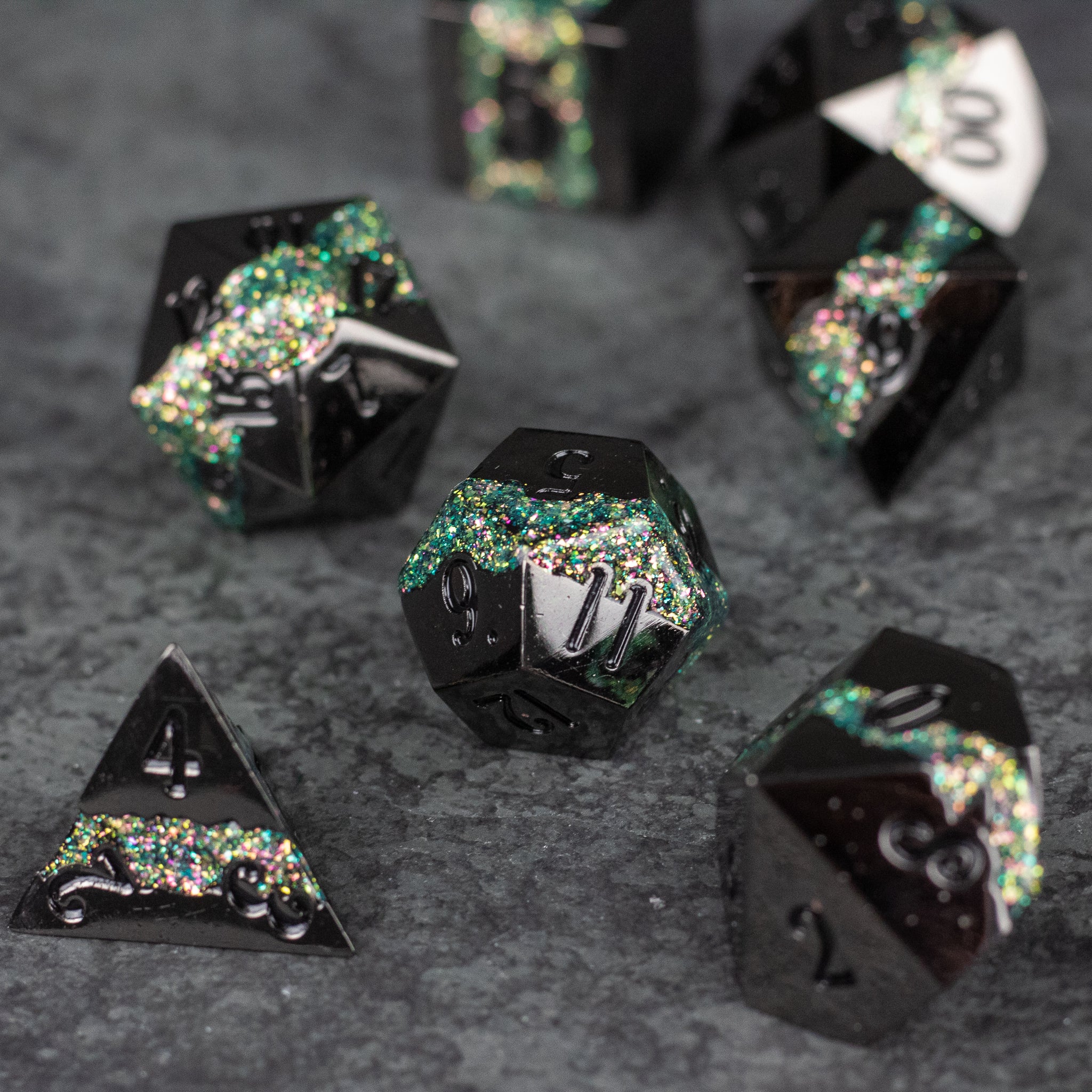 Light Green Rift Dice Set - Black metal dice with light green and silver glitter embedded, seven-piece set on dark surface.