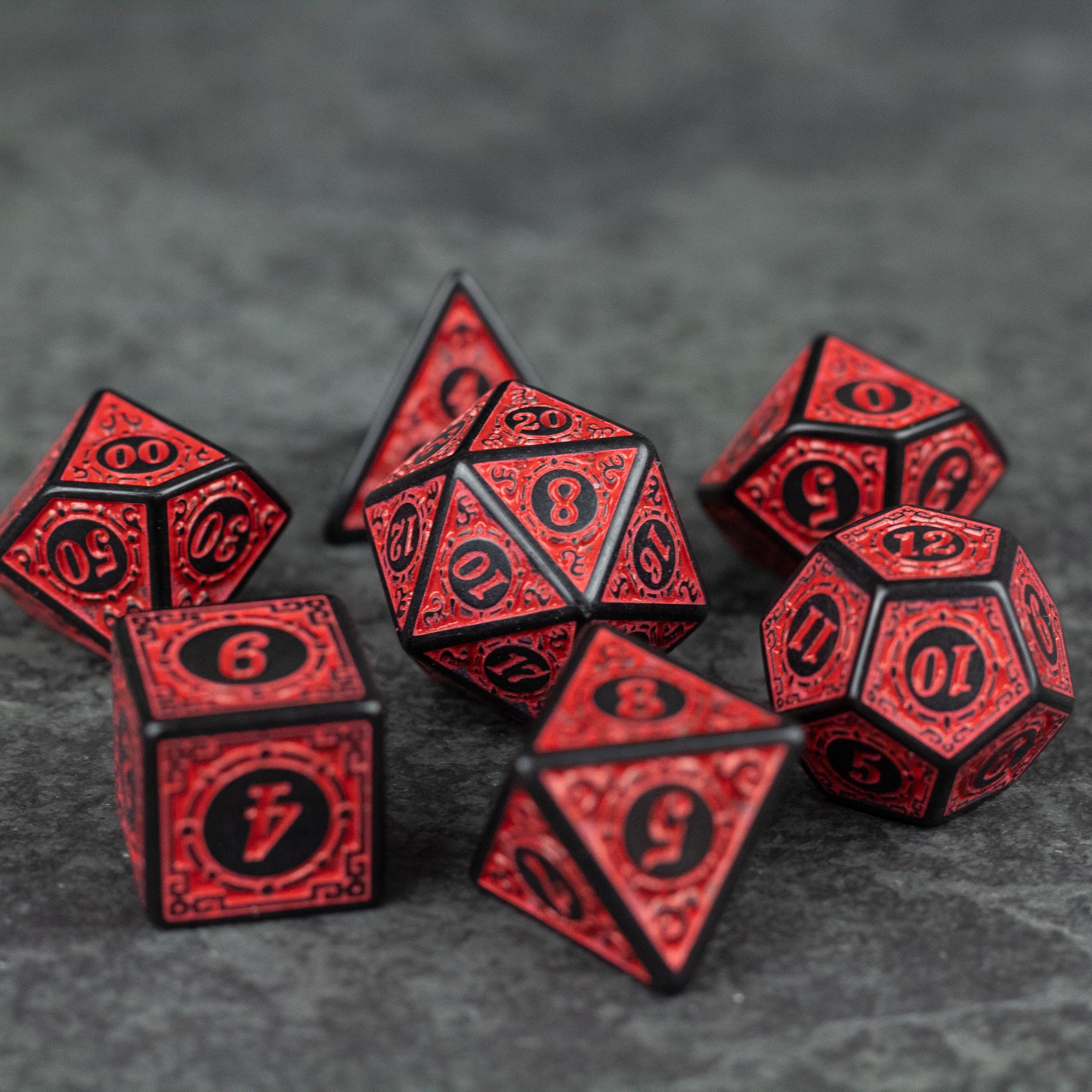 Red Runes Acrylic Dice Set - Set of seven red acrylic dice with black intricate rune-like markings, including shapes like d4, d6, d8, d10, d12, and d20.