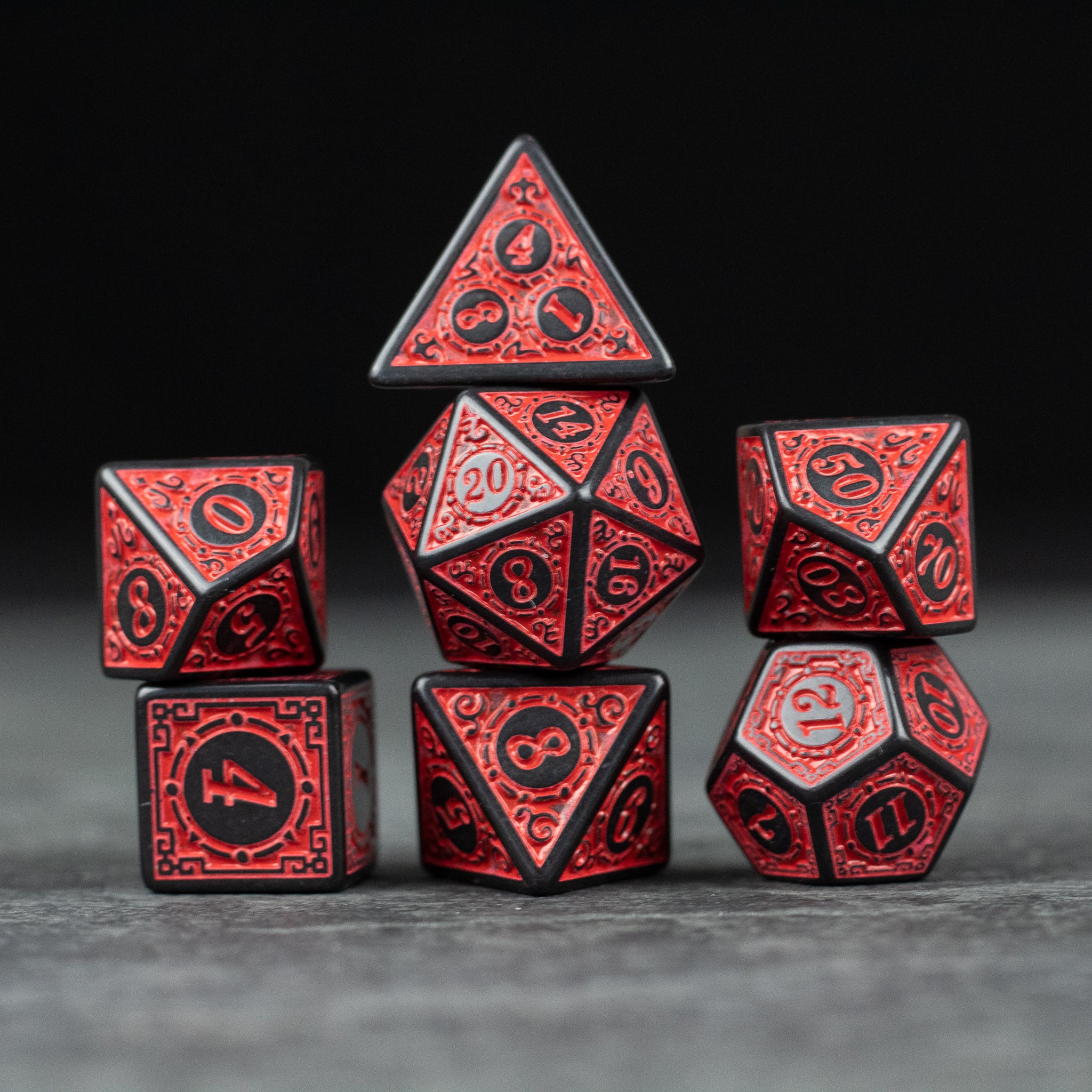 Red Runes Acrylic Dice Set - Set of seven red acrylic dice with black edges and intricate rune-like designs on each face.