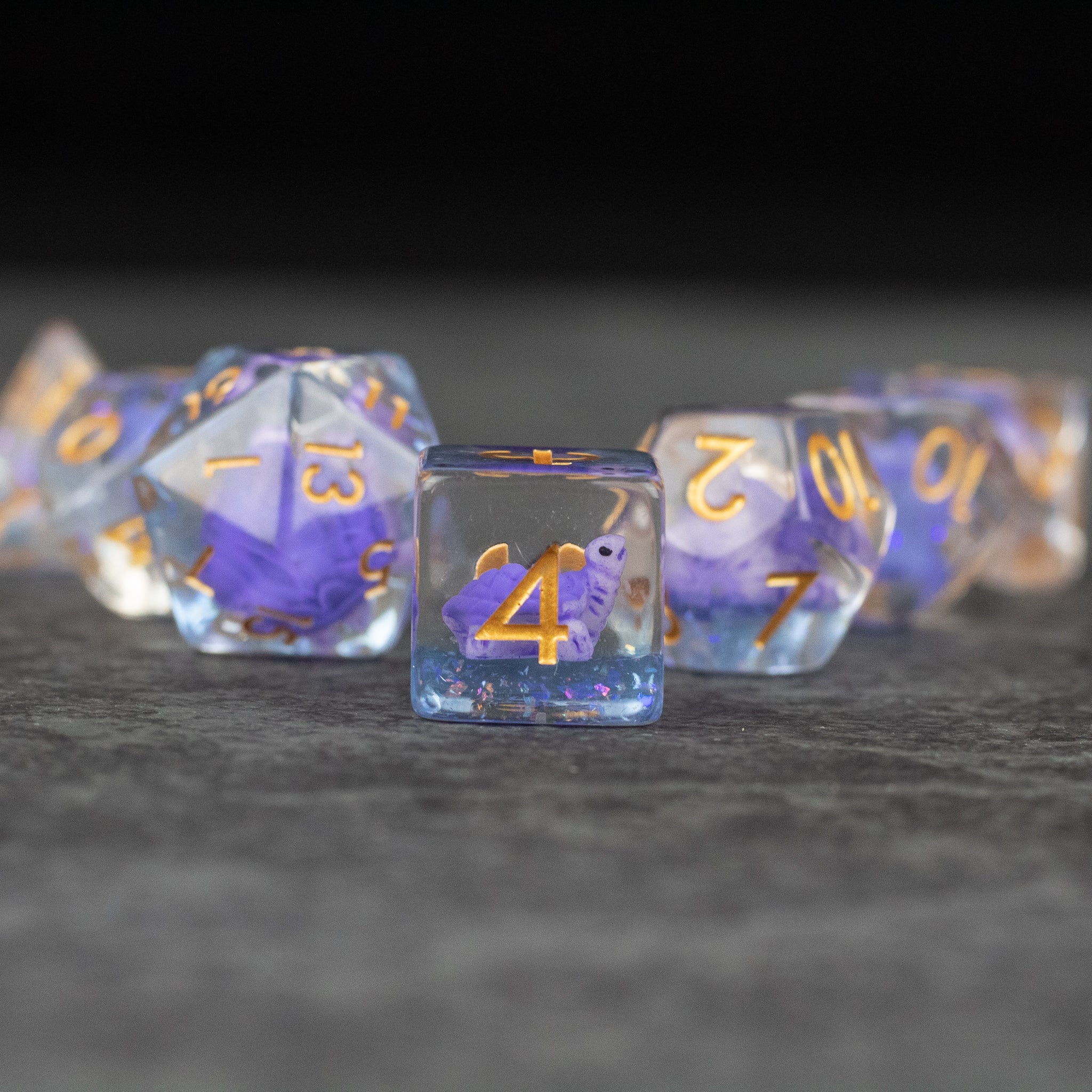 Purple Turtle Dice Set - Purple translucent dice set with gold numbers and miniature turtle inclusions inside each die.