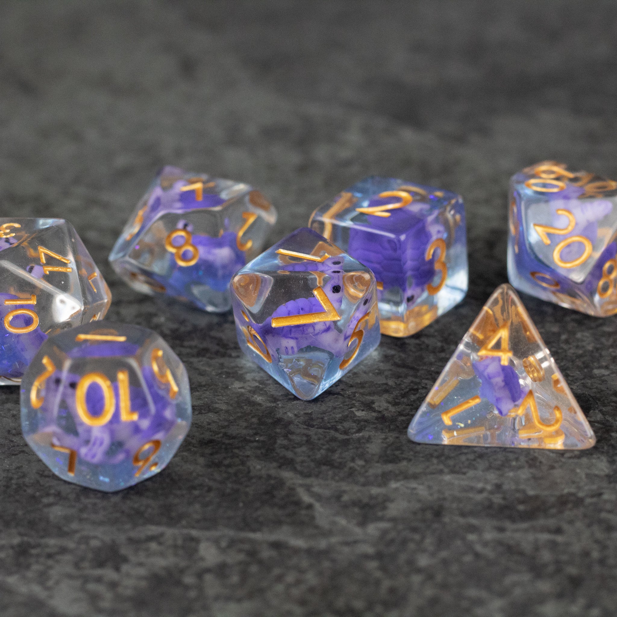 Purple Turtle Dice Set - Set of seven translucent purple polyhedral dice with gold numbers, featuring embedded turtle shapes inside.