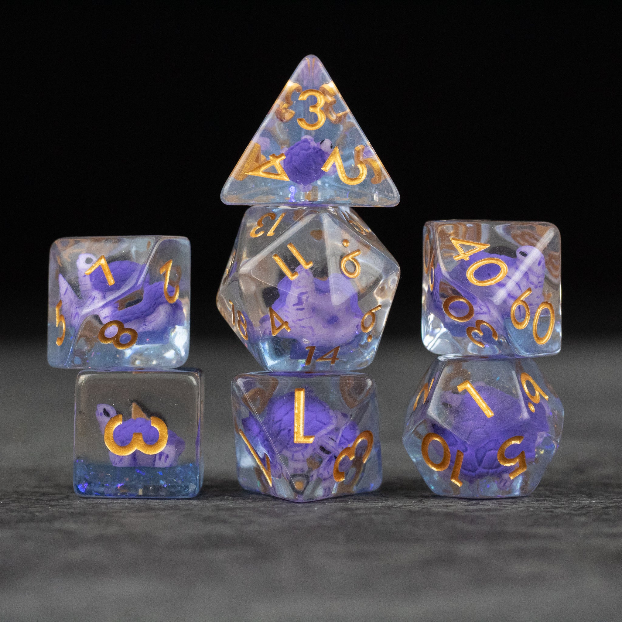 Purple Turtle Dice Set - Purple translucent seven-piece dice set with gold numbers and embedded turtle shapes.