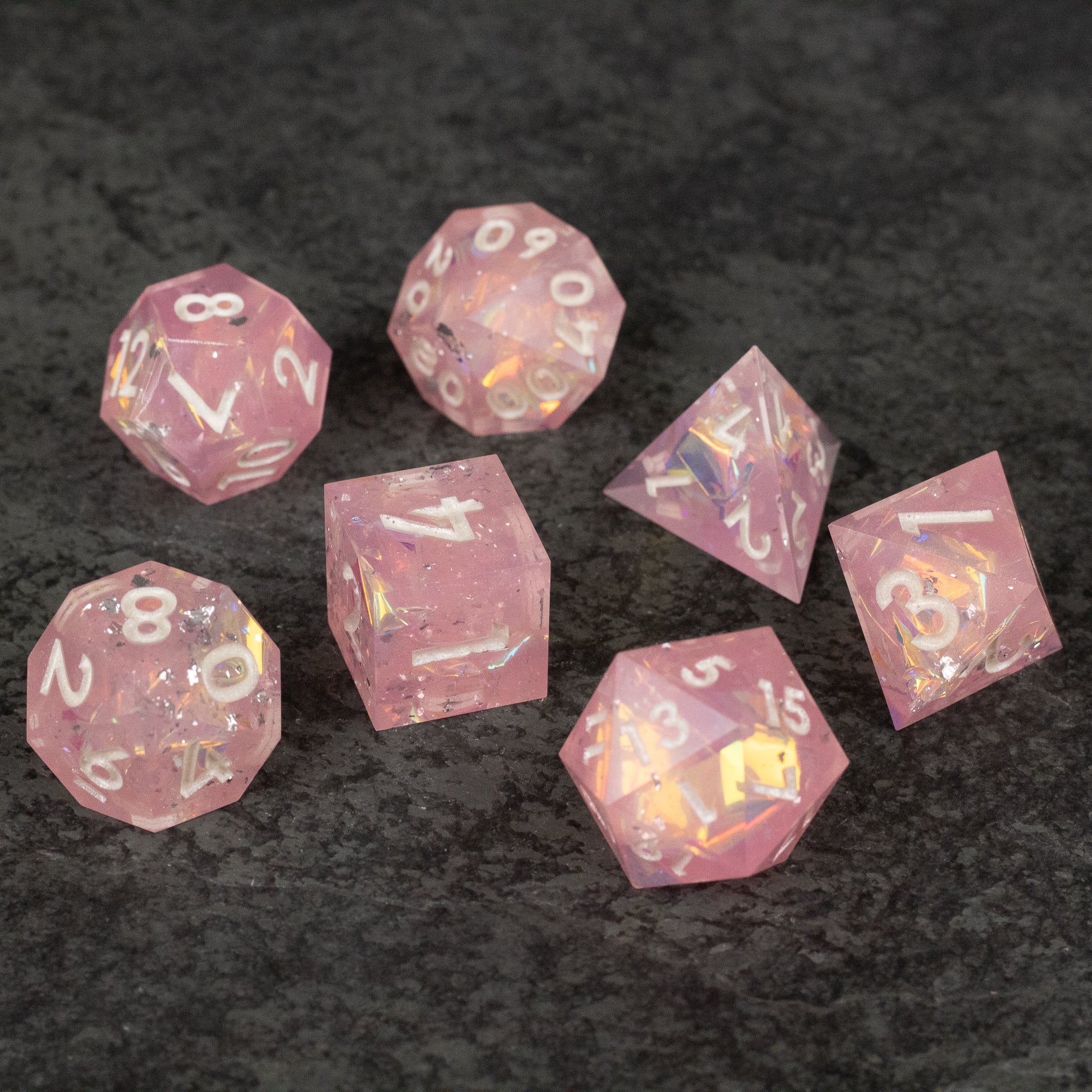 Bubblegum Dice Set - Set of seven translucent pink polyhedral dice with sharp edges and white numbering, designed for tabletop games.