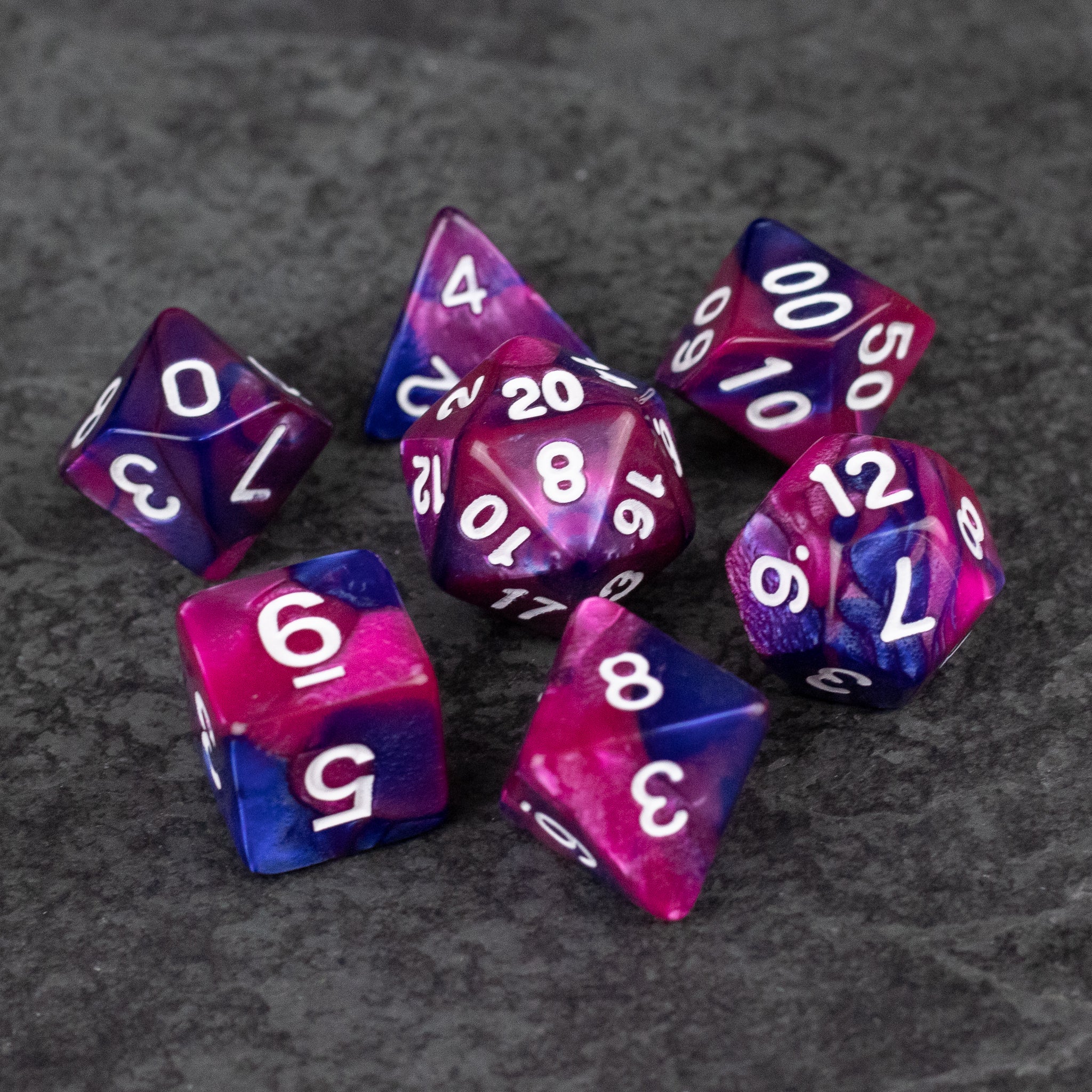Pink and Blue Marbled Dice Set - Set of pink and blue marbled acrylic dice with white numbering, including d20, d12, d10, d8, d6, and d4.