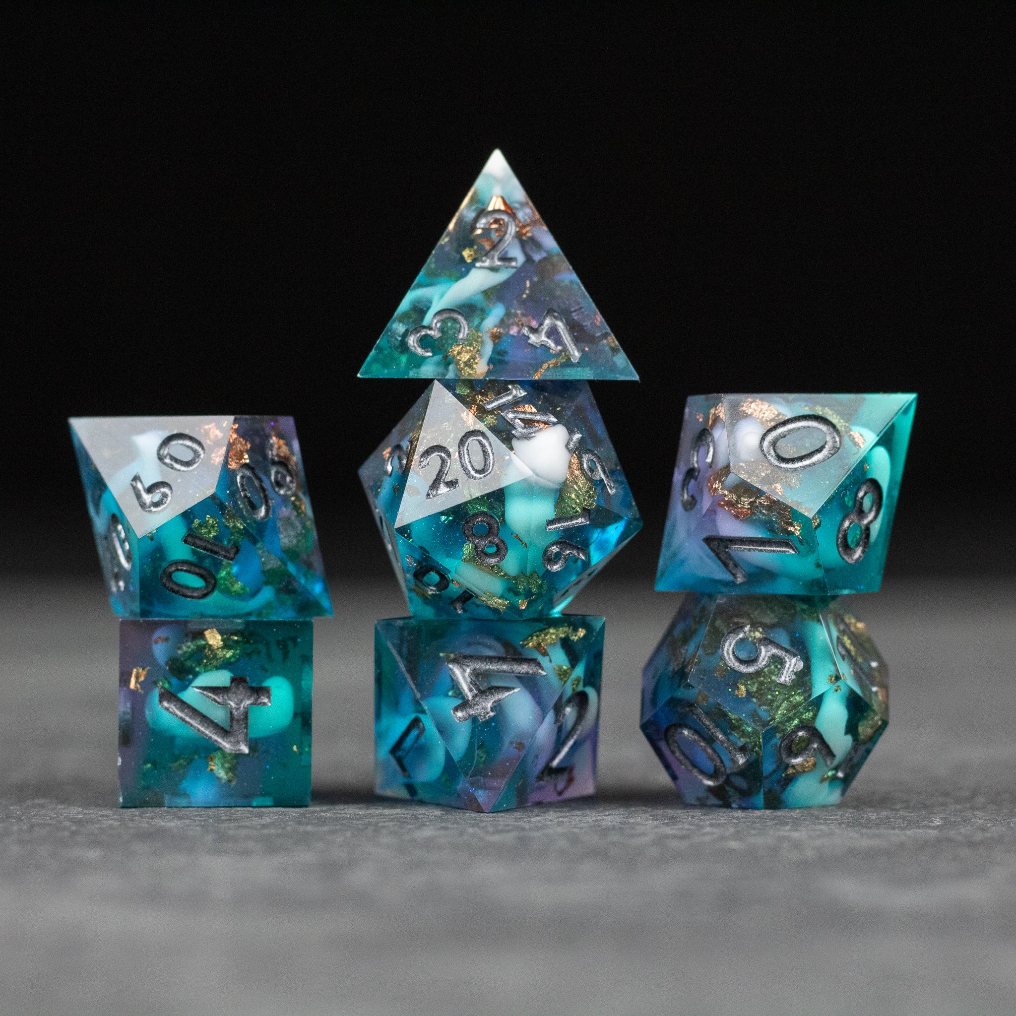 Frostfall Dice Set - Six sharp-edged polyhedral dice set with swirling blue, teal, and purple colors, silver numbers.