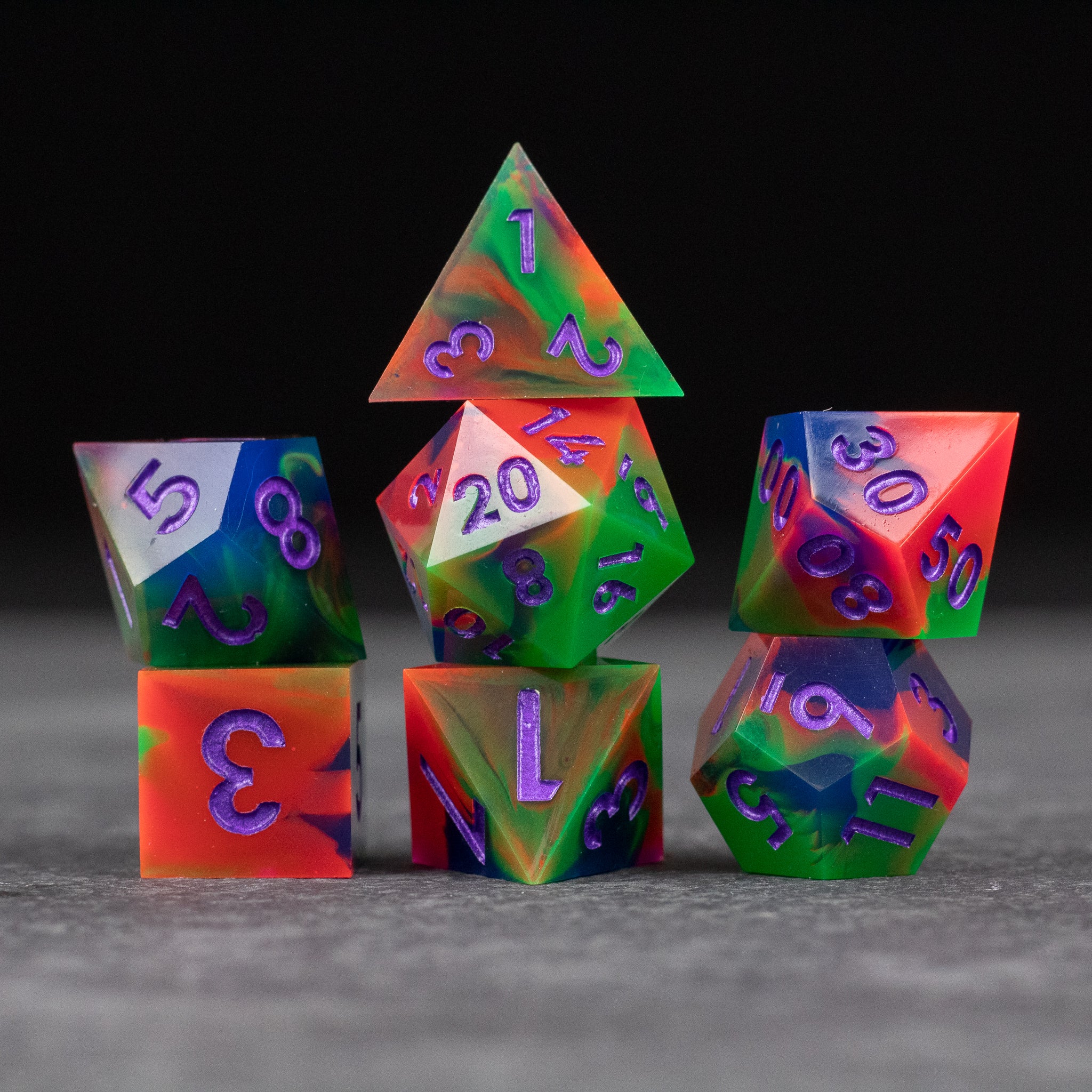 Neon Demon Dice Set - Set of sharp-edged neon green and pink polyhedral dice with glowing numbers on gray surface.