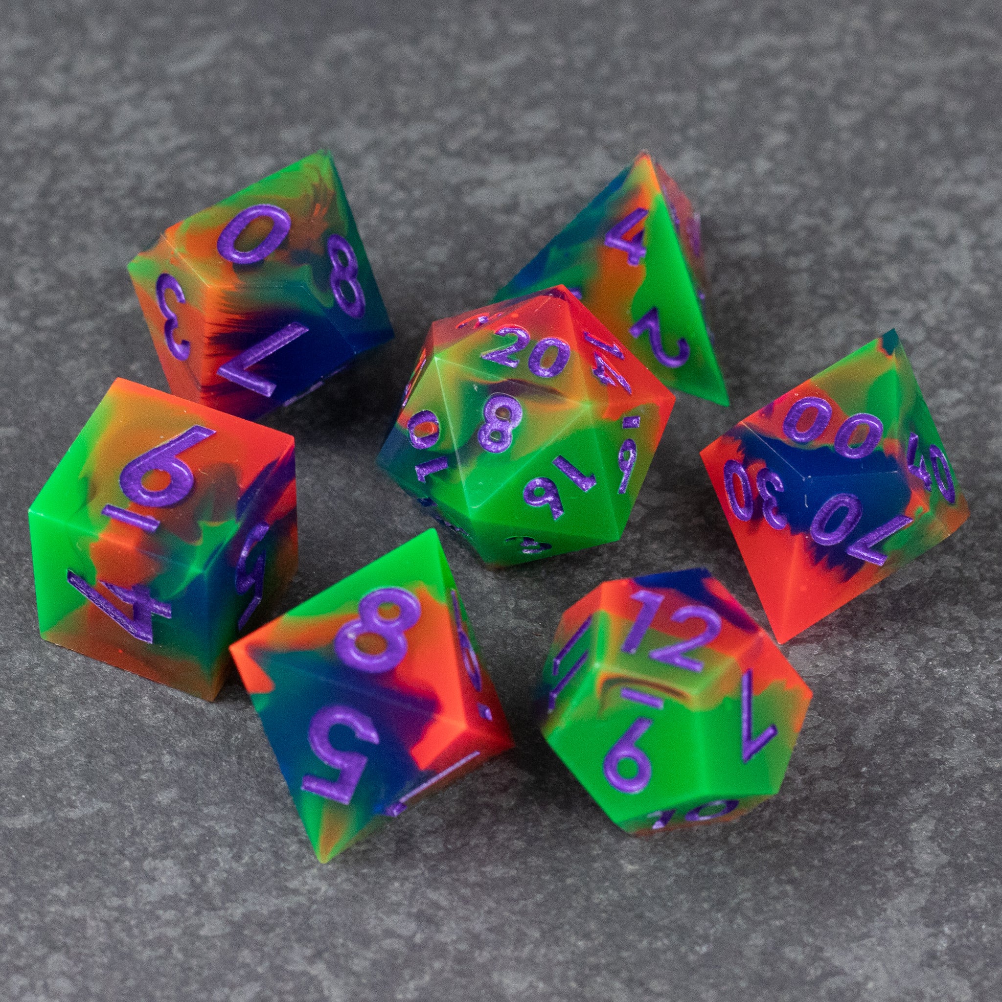 Neon Demon Dice Set - Seven-piece dice set with sharp edges in neon green, pink, and purple swirl design.