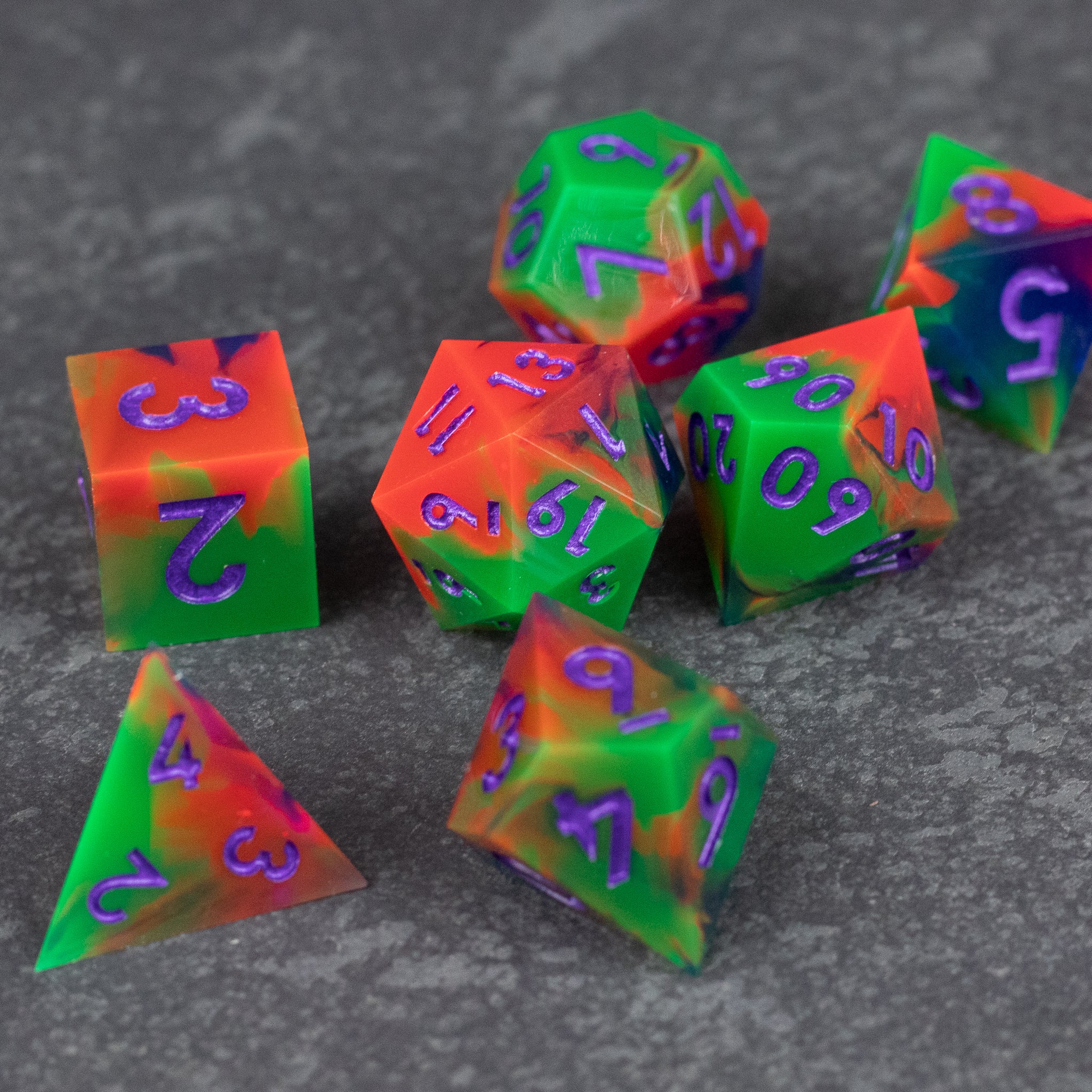 Neon Demon Dice Set - Seven sharp-edged dice with a neon split color design in green and pink, featuring purple numbers.