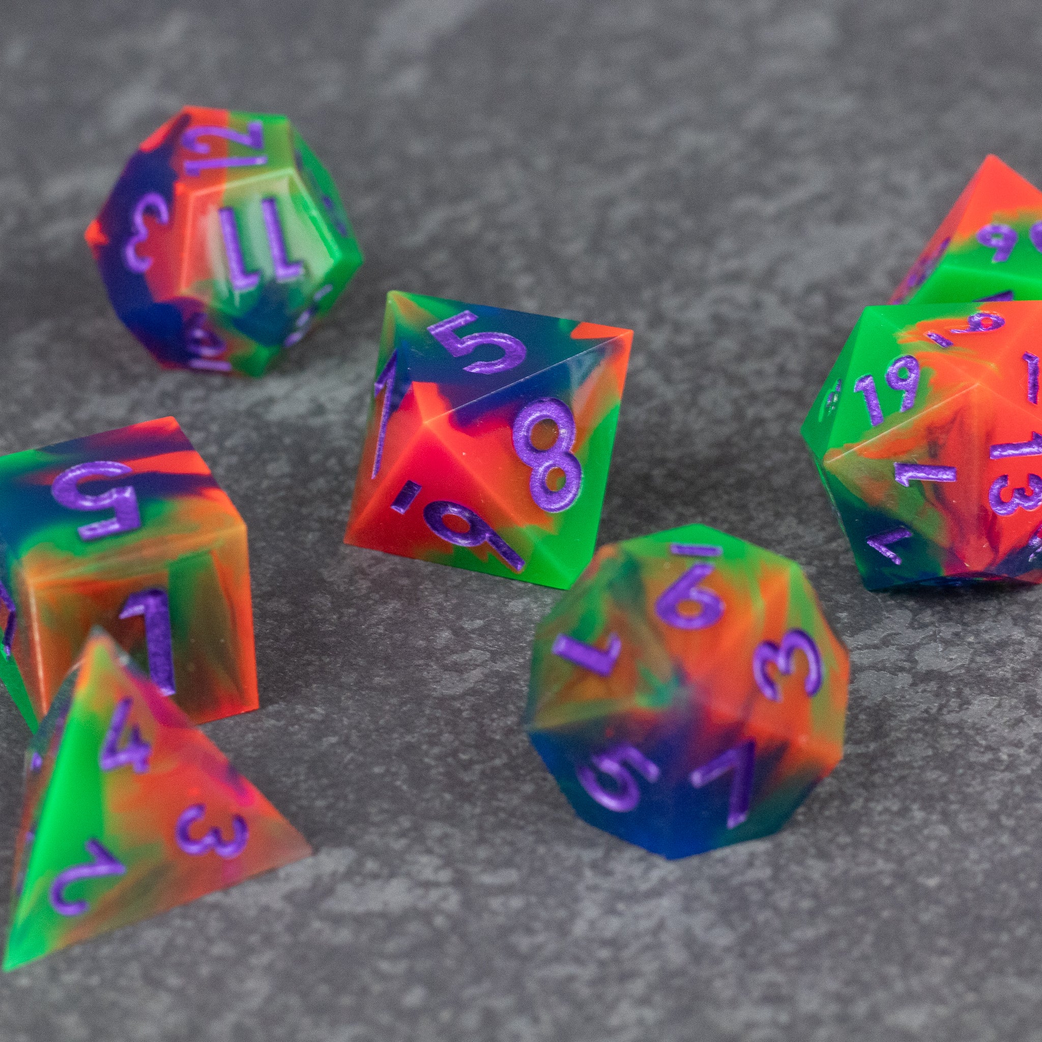 Neon Demon Dice Set - Bright neon dice set with sharp edges featuring green, pink, and purple swirls on a dark background.